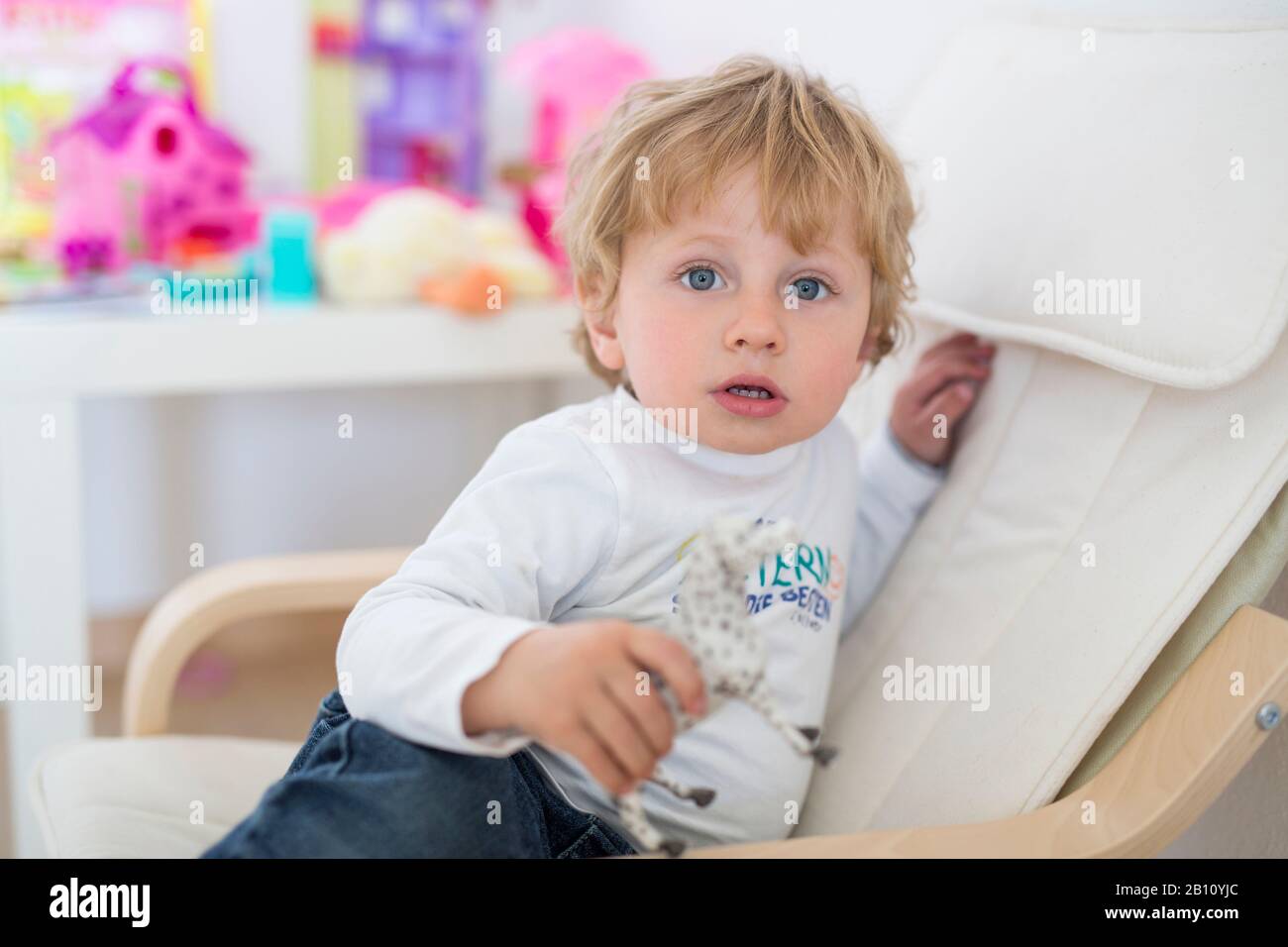 Der kleine Junge sitzt in einem Sessel Stockfoto