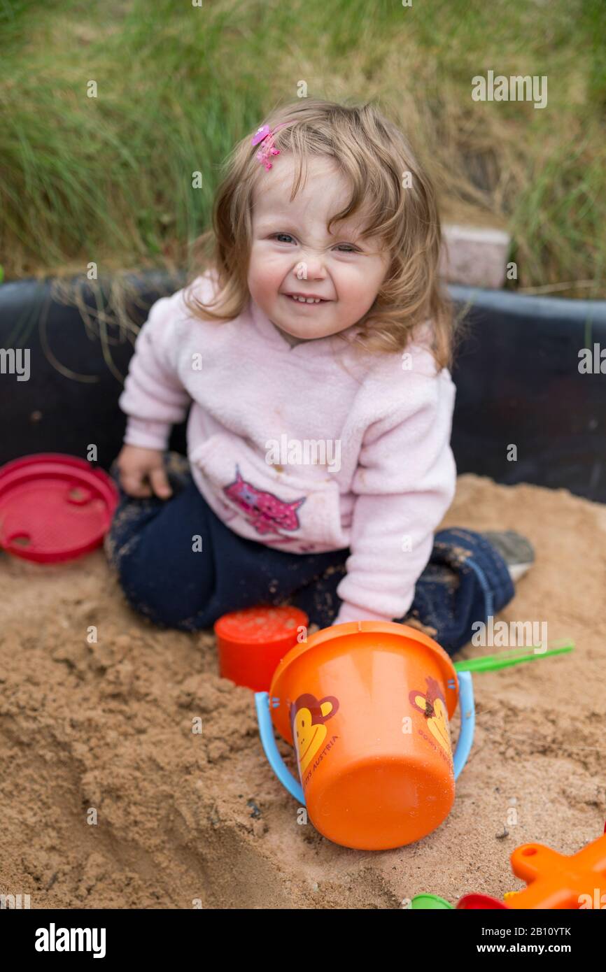 Kleines Mädchen spielt im Sandkasten Stockfoto