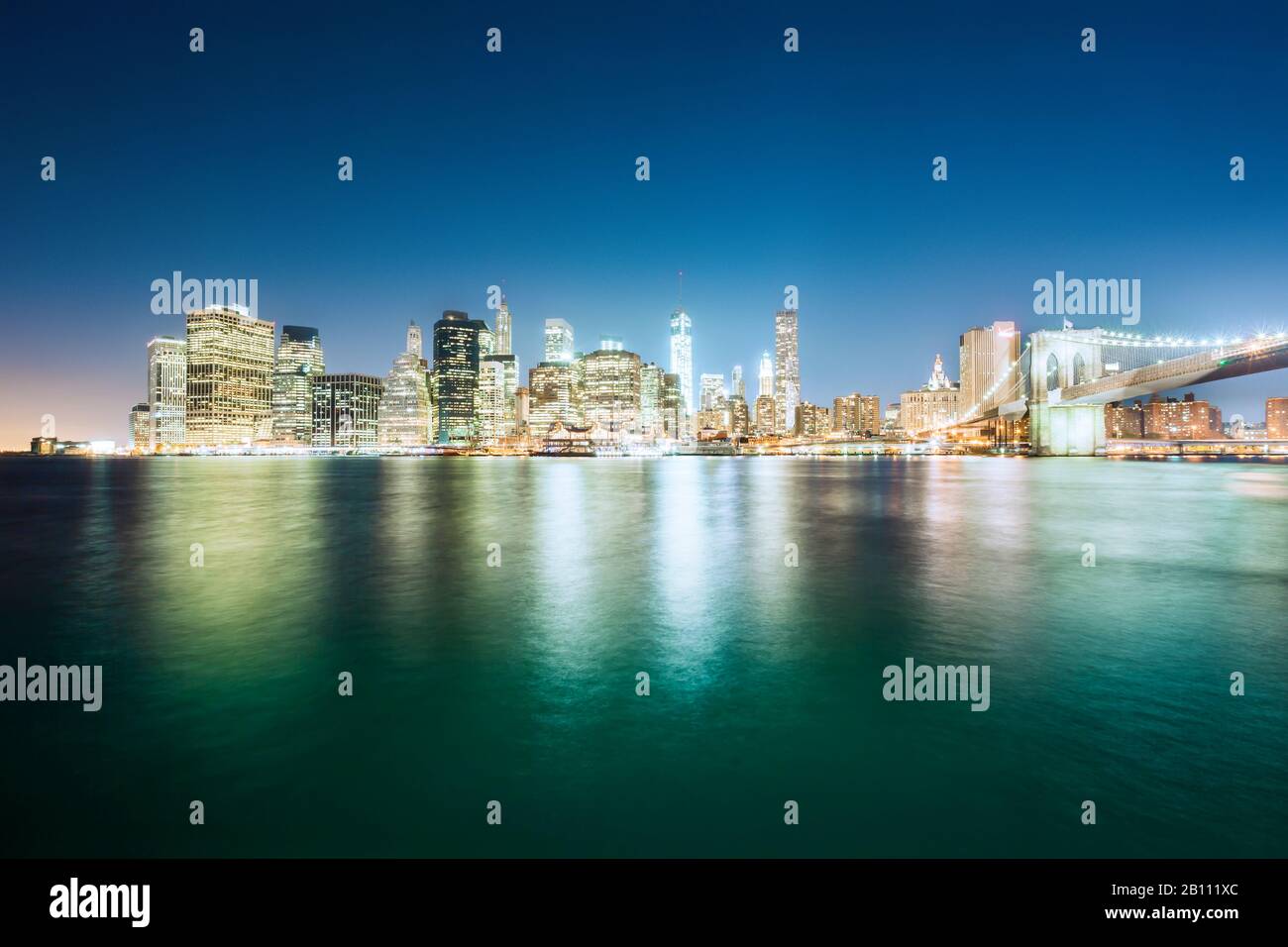 Downtown, Manhattan Skyline nachts mit Brooklyn Bridge und One World Trade Center, New York, USA Stockfoto