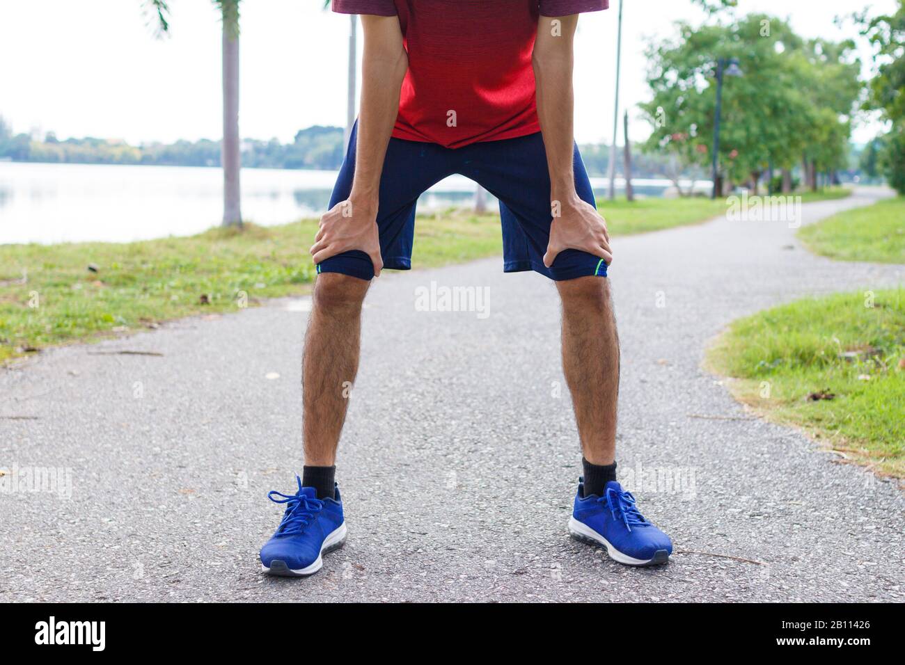 Müde junge Mann-Läuferin, die sich nach dem laufen ausruhen kann.Workout-Konzept Stockfoto