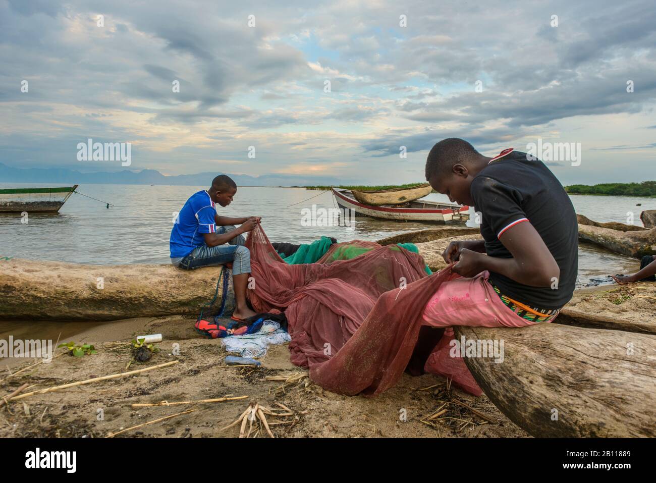 Zwei Fischer bringen ihre Netze auf einem Fischmarkt am Malawi-See, Malawi, Afrika Stockfoto