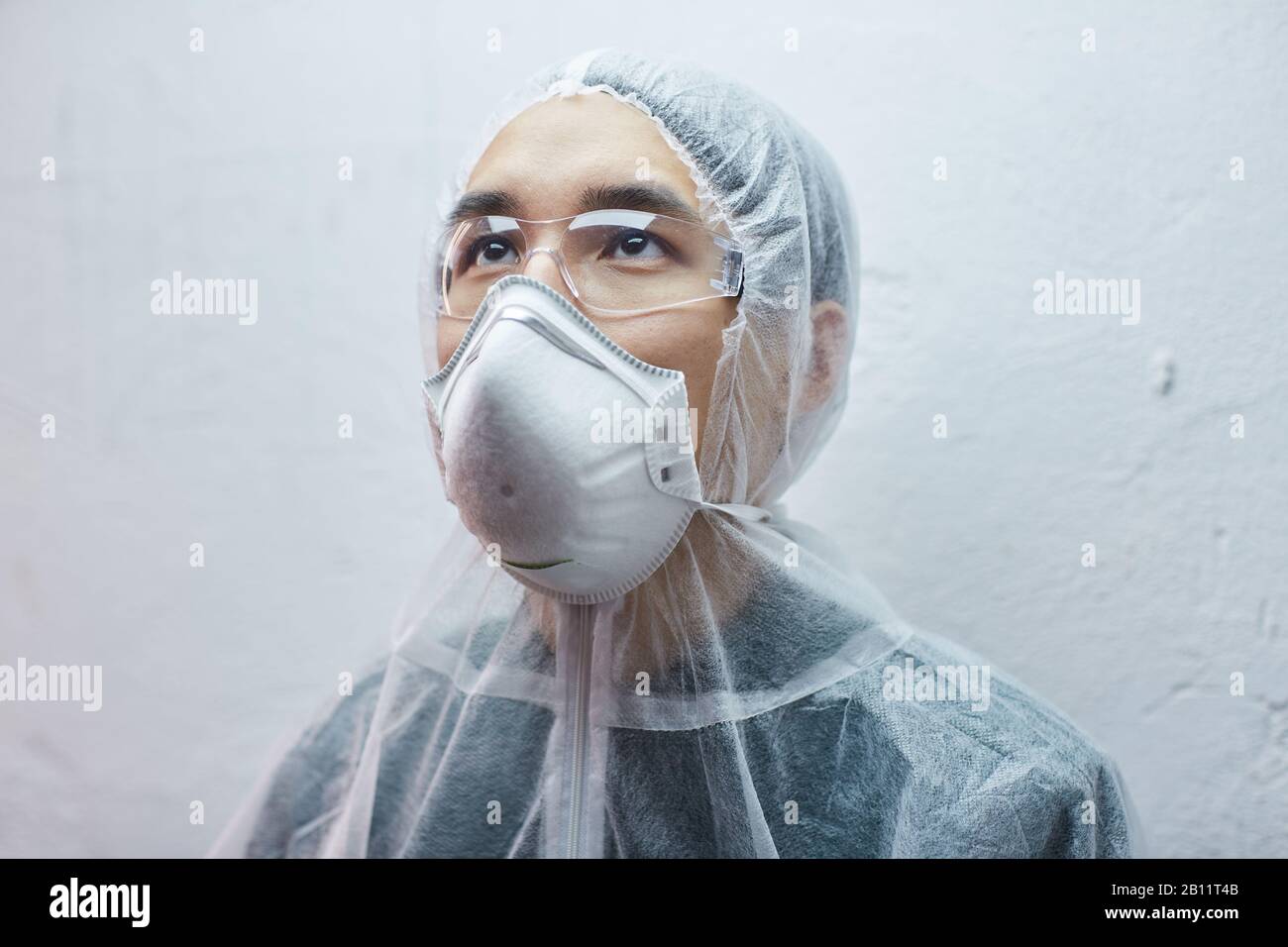Asiatischer junger Mann in Schutzmaske und Brille isoliert auf weißem Hintergrund Stockfoto