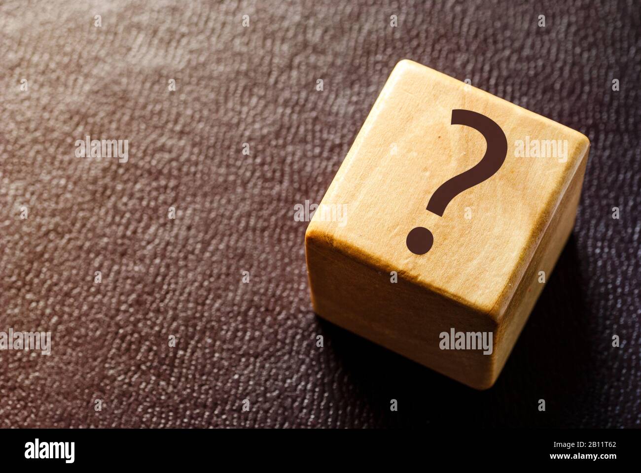 Holzspielzeugblock mit schwarzem Fragezeichen Stockfoto