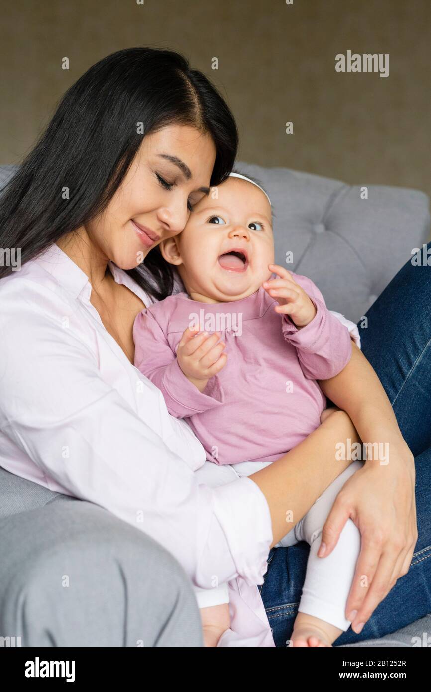 Mutter sitzt mit Baby auf einem Stuhl Stockfoto
