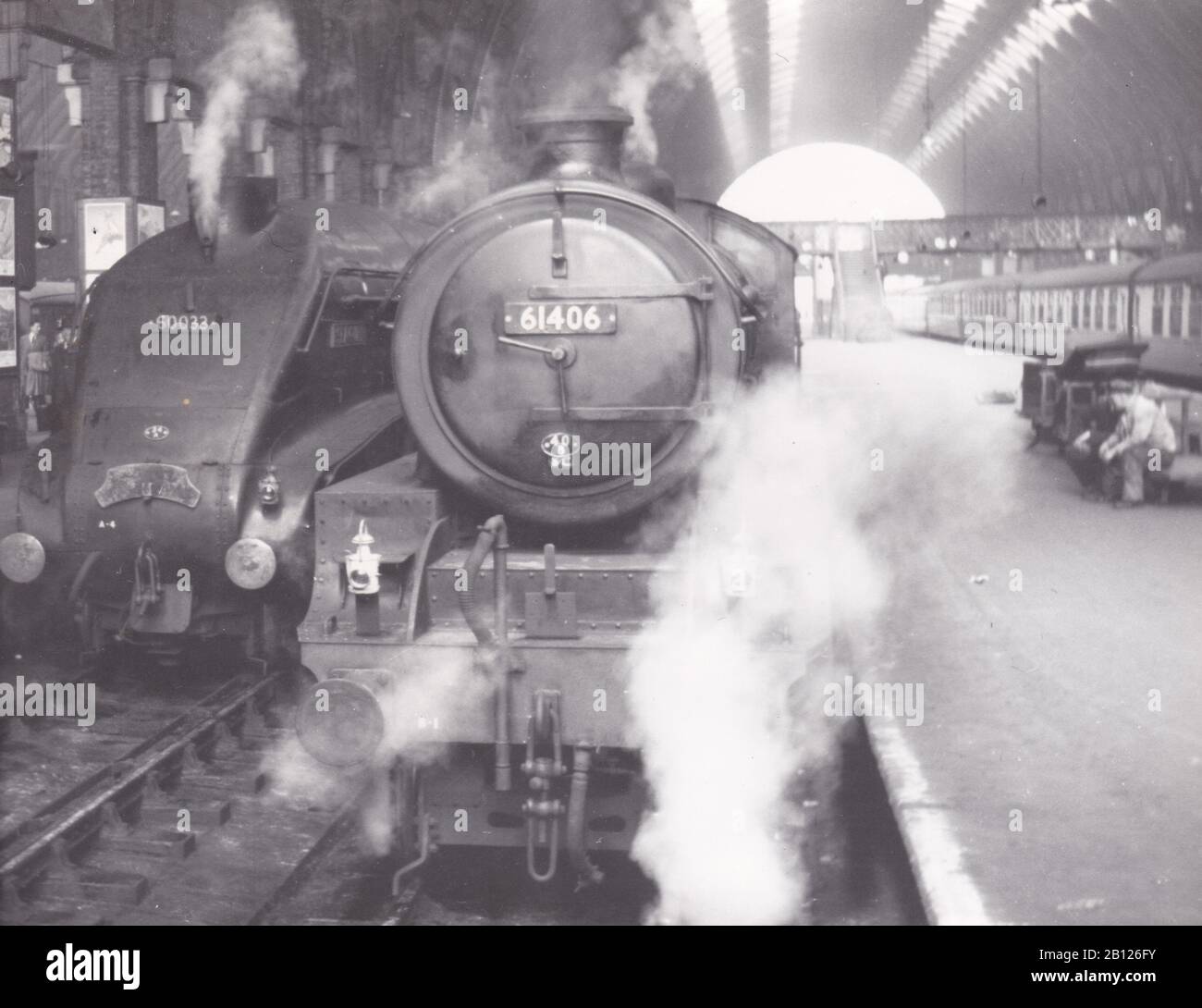 Klassisches Schwarzweißfoto der Dampflokbahn - 803 61406 und 143 - 60033 am Kings Cross Station 10. Mai 1957. Stockfoto