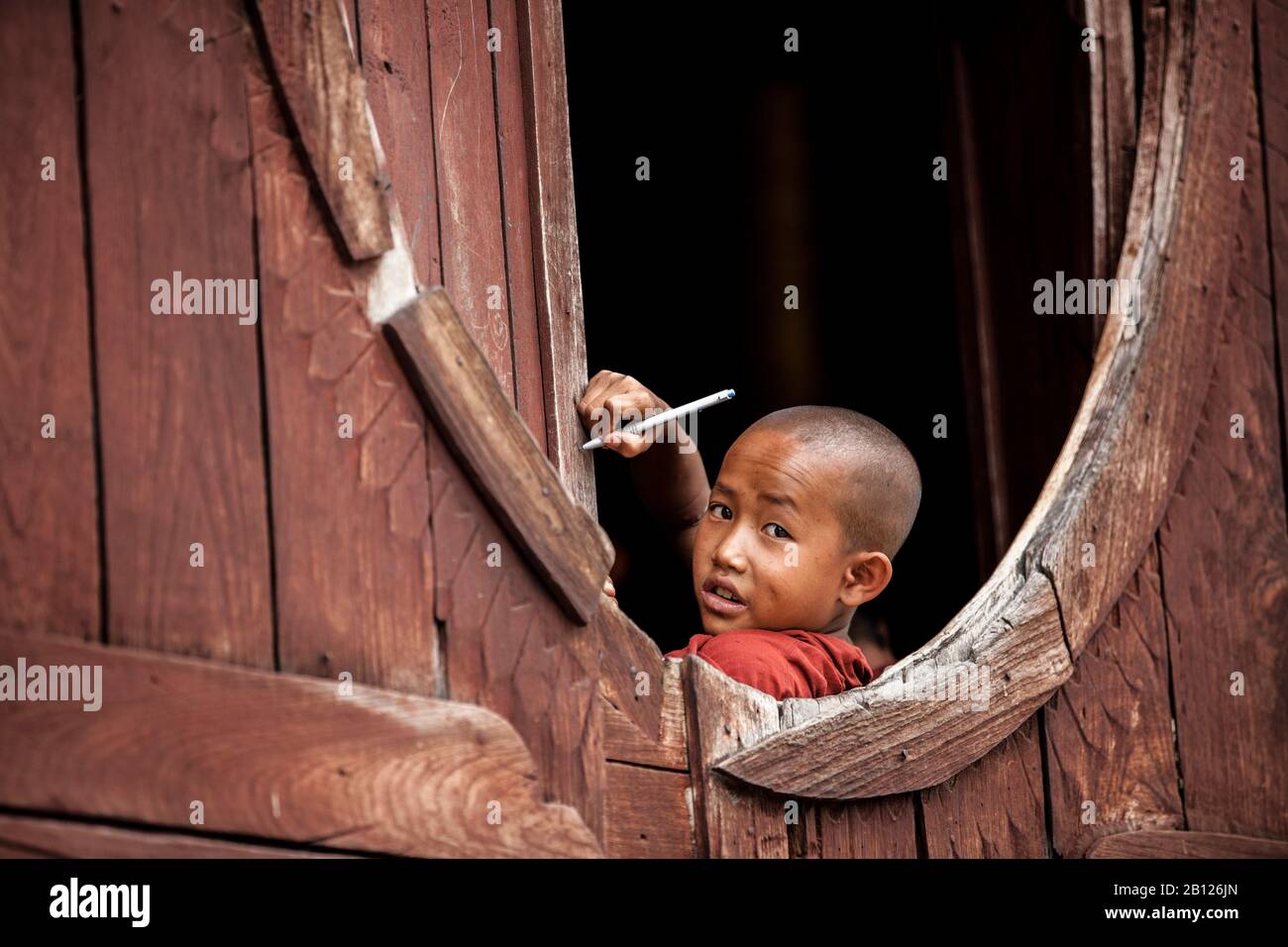 Junger Mönch, der auf dem Fenster des Klosters Shwe Yaunghwe Kyaung schreibt. Nyaung Shwe, Myanmar Stockfoto