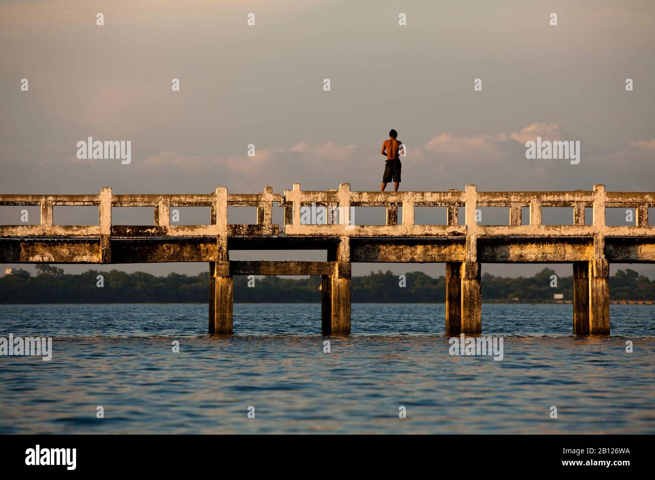 Mann steht über U Beins Brücke. Amarapura, Myanmar Stockfoto