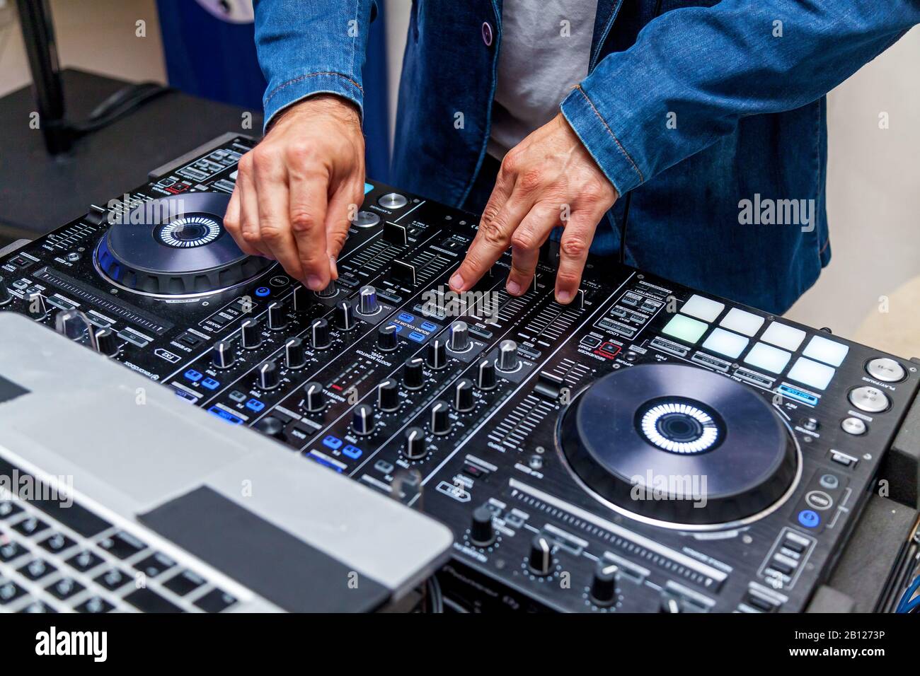 Ein Mann, der Musik auf einem Audiomixer spielt und Tracks auf der Strandparty mischt Stockfoto