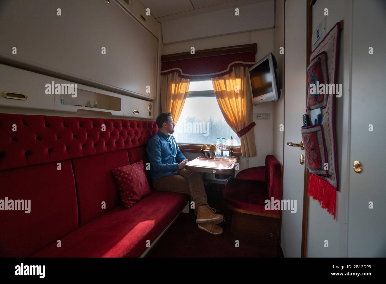 Transsibirische Eisenbahn im Winter, Mann im Zug sitzen Blick aus Fenster, Russland Stockfoto