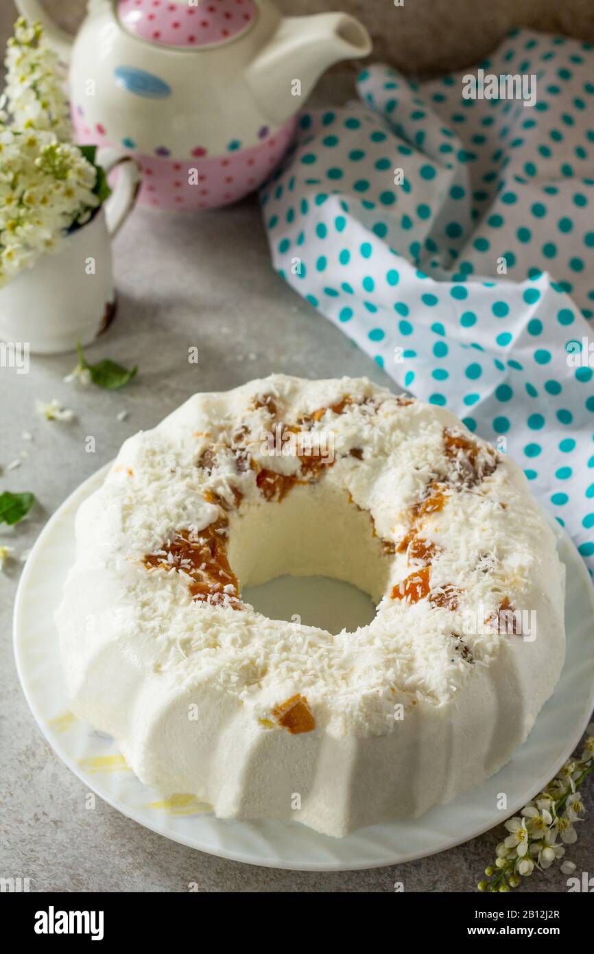 Pannacotta-Dessert. Cottage Käsesuffle Panna Cotta mit Aprikosen und Kokosnuss auf einem Stein oder Schiefer auf einem hellen Arbeitsplatte. Kopierbereich. Stockfoto