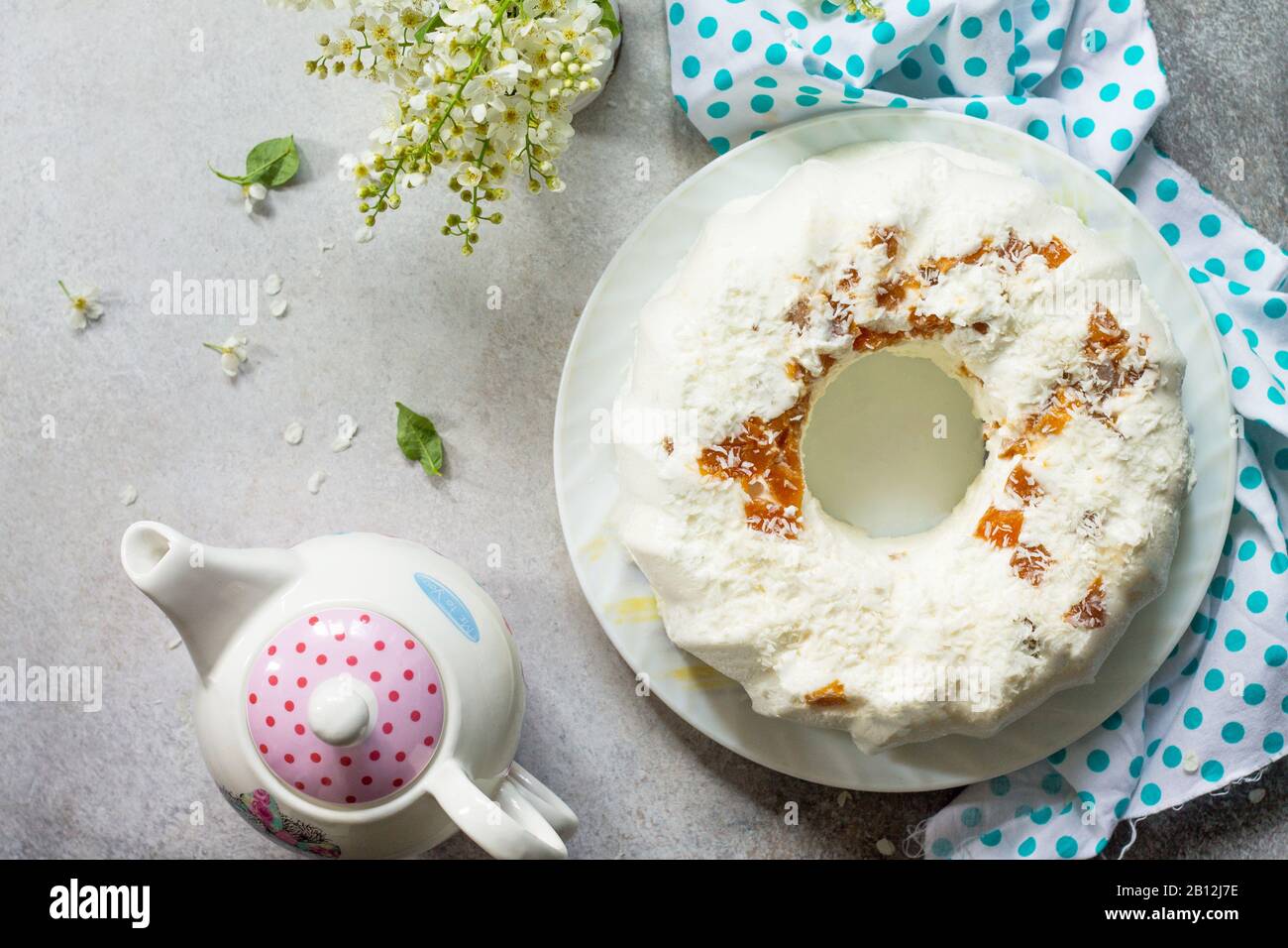 Pannacotta-Dessert. Cottage Käsesuffle Panna Cotta mit Aprikosen und Kokosnuss auf einem Stein oder Schiefer auf einem hellen Arbeitsplatte. Oberansicht flach Lay BA Stockfoto
