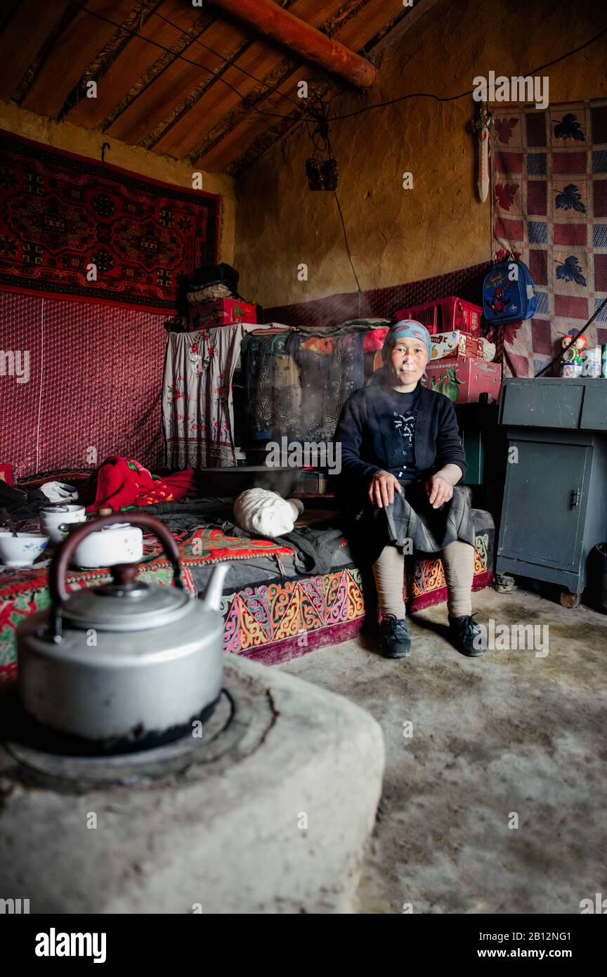 Traditionelle uigurische Frauen im abgelegenen Xinjiang bleiben im Haus, um die täglichen Aufgaben zu erledigen. Kochen, Brot backen, Tee zubereiten, die Kinder im Blick haben, während die Männer draußen arbeiten. Stockfoto