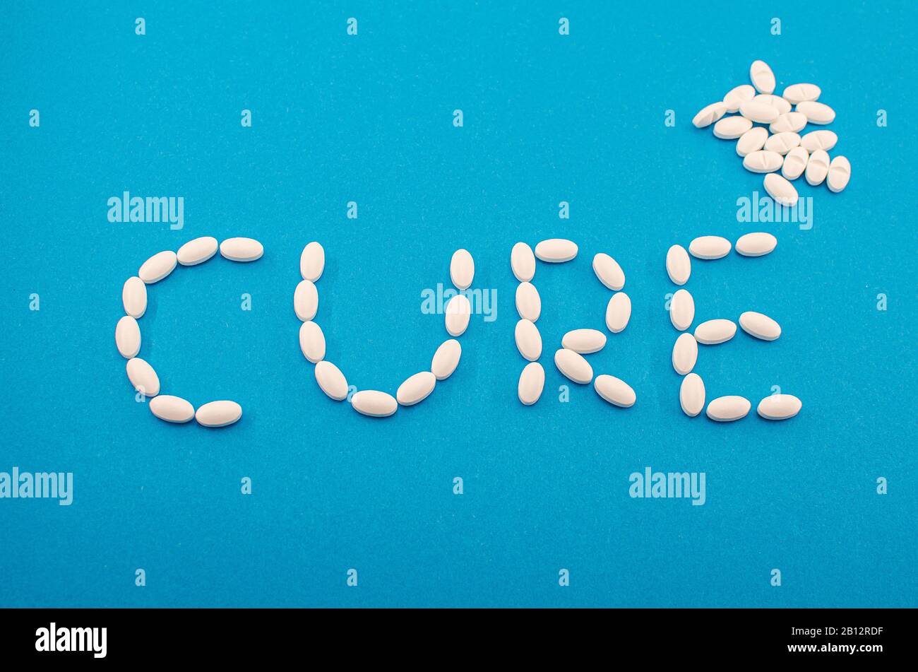 Medizinische weiße Pillen, Tabletten, die das Wort Heilung auf blauem Hintergrund bilden. Medizin, Drogenbehandlung von Krankheiten. Konzept der chinesischen Coronavirus Heilung. Stockfoto