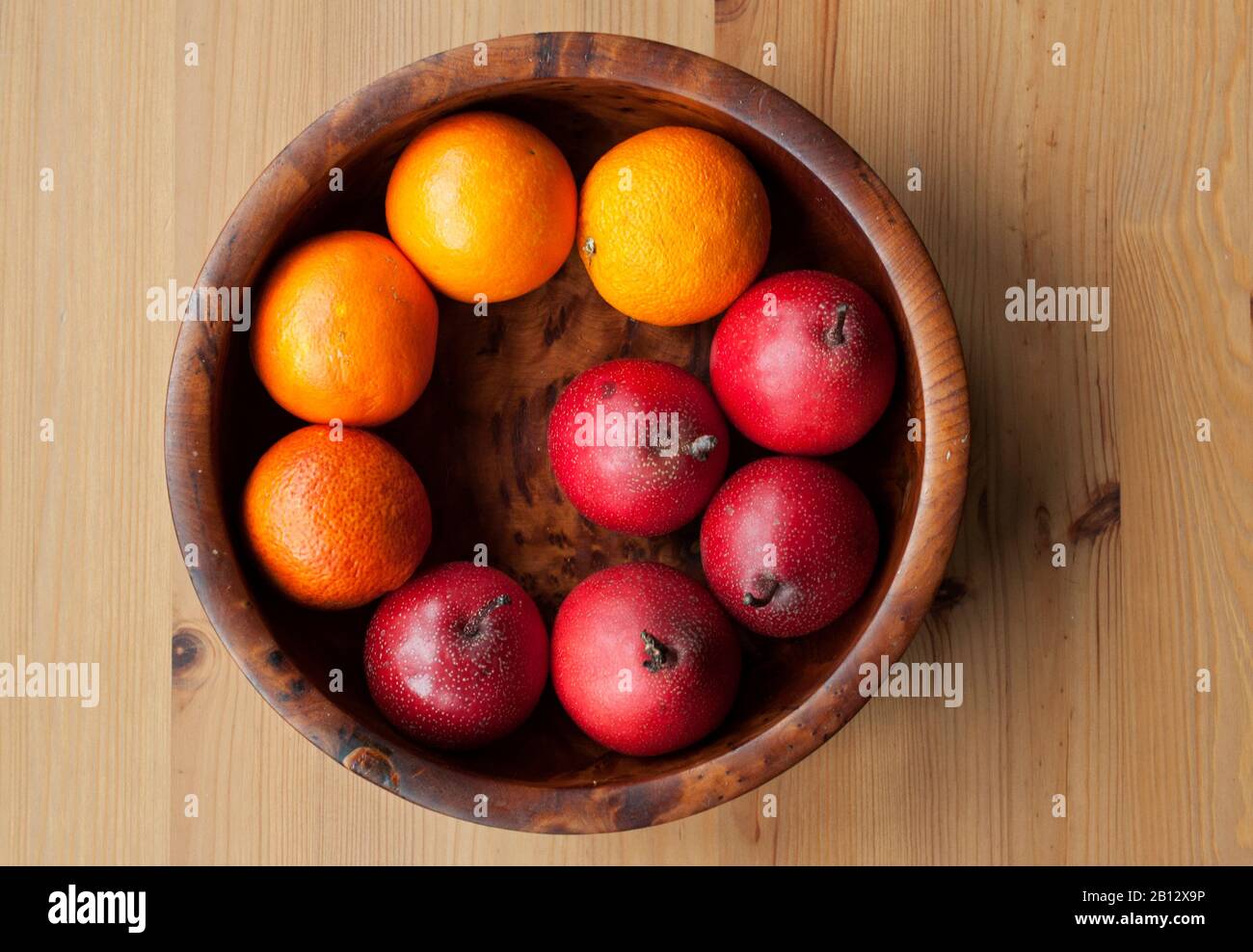 Oben auf einer Holzkitchtta aus wunderschöner Holzschale aus Autum und Winterfrüchten - Blutorangen und Naschi-Birnen (asiatische Birnen, japanische Birnen) Stockfoto