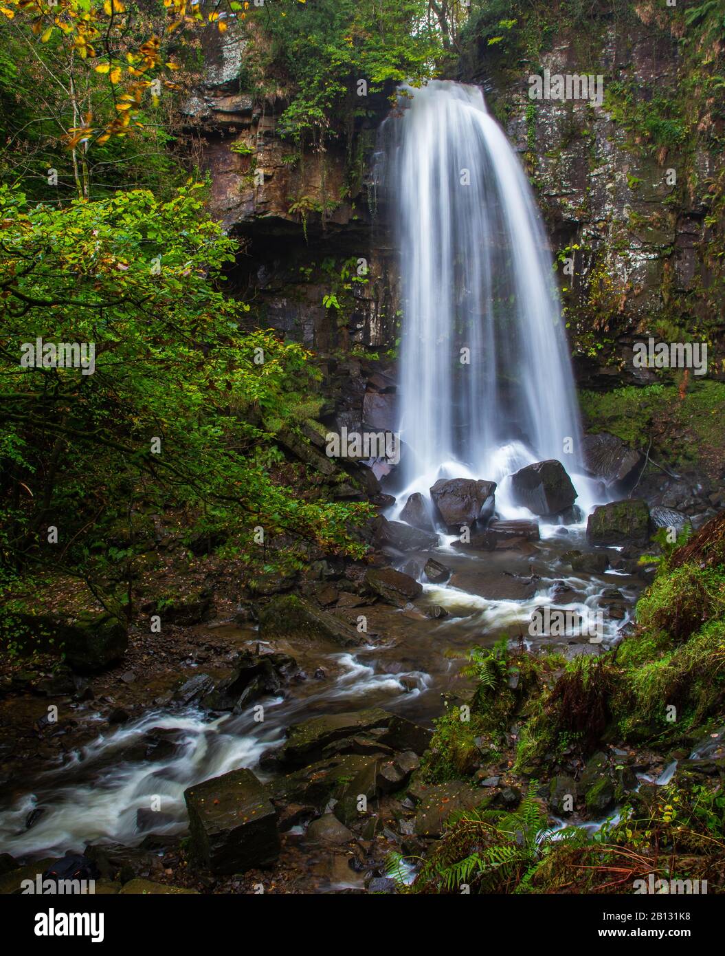 Der Wasserfall Melincourt Falls spritzt auf nassen Felsen Stockfoto