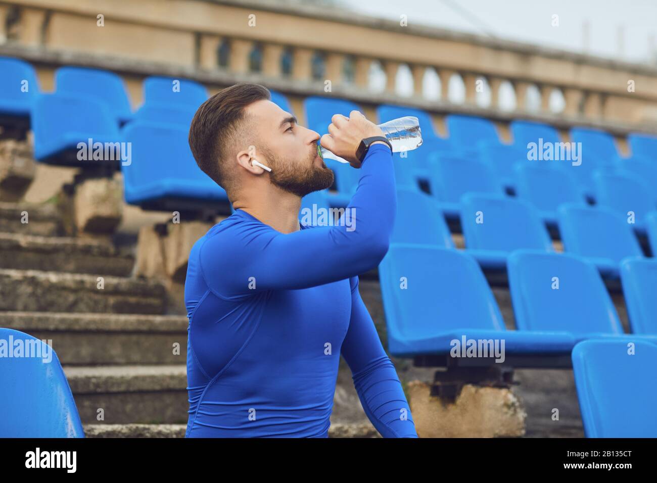 Ein Kerl in Sportswear sitzt im Stadion nach dem Training. Stockfoto