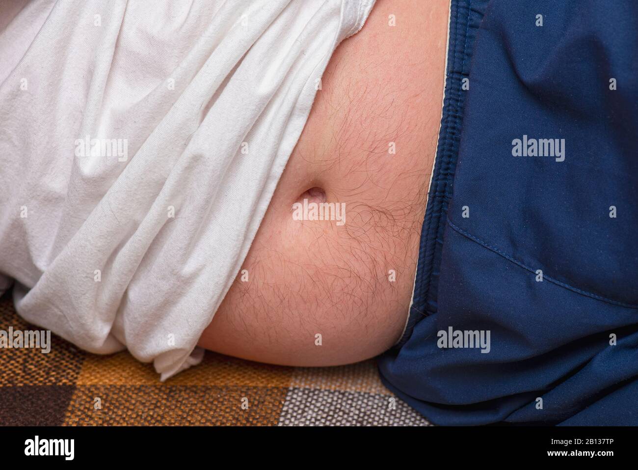 Fett Мan auf dem Sofa liegend, Mann mit Оverweight Stockfoto