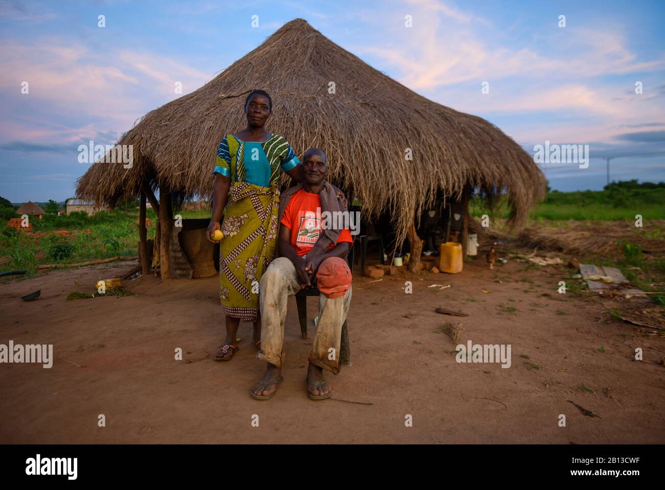 Ein Paar vor einer Strohhütte, Mosambik, Afrika-Paar vor einer Strohhütte, Mosambik, Afrika Stockfoto