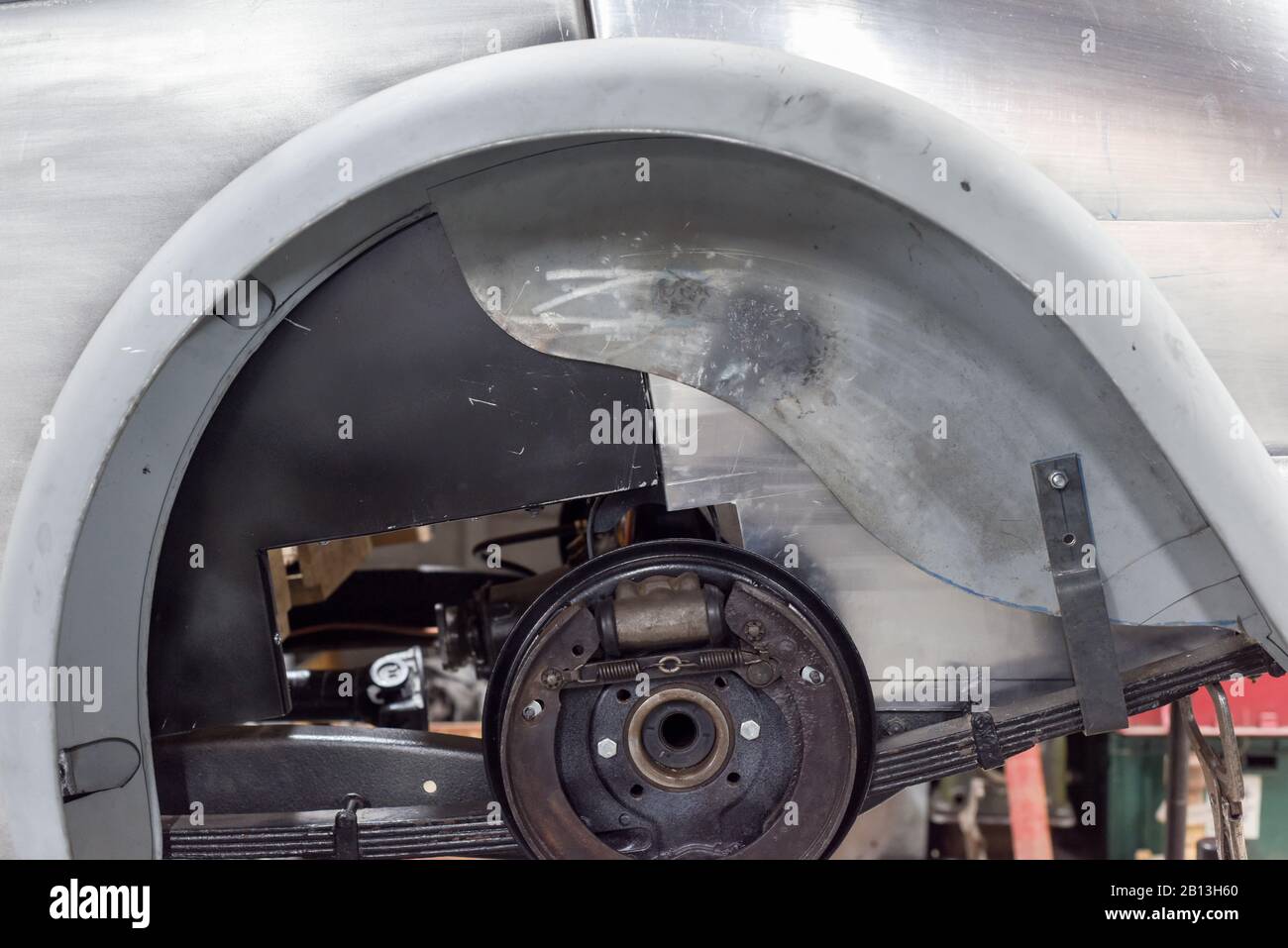 Oldtimer mit freiliegender Achse und ausgebautem Hinterrad zur Reparatur in der Garage Stockfoto