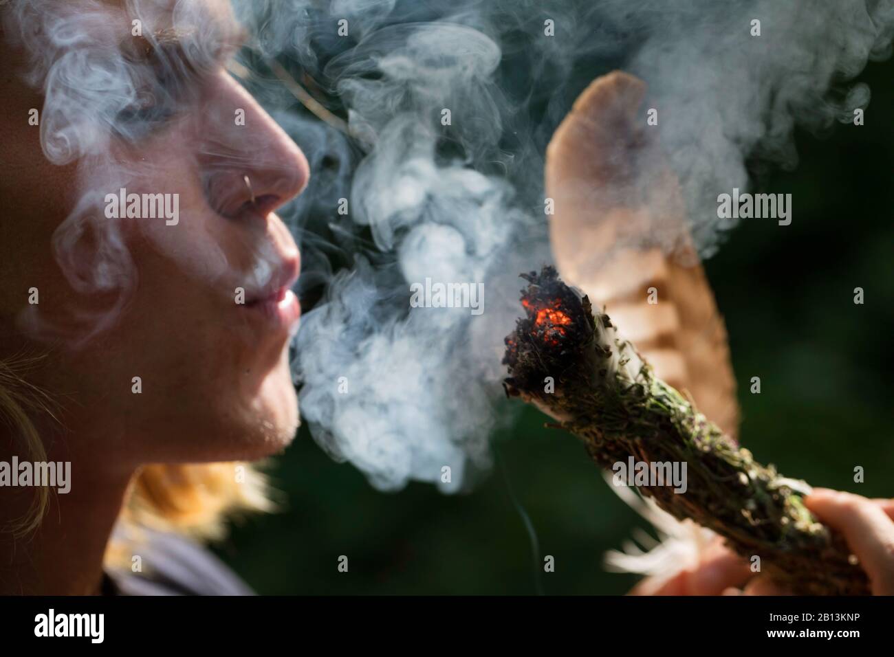 Aushärtung, junger Mann, der die Flamme bläst, Deutschland Stockfoto