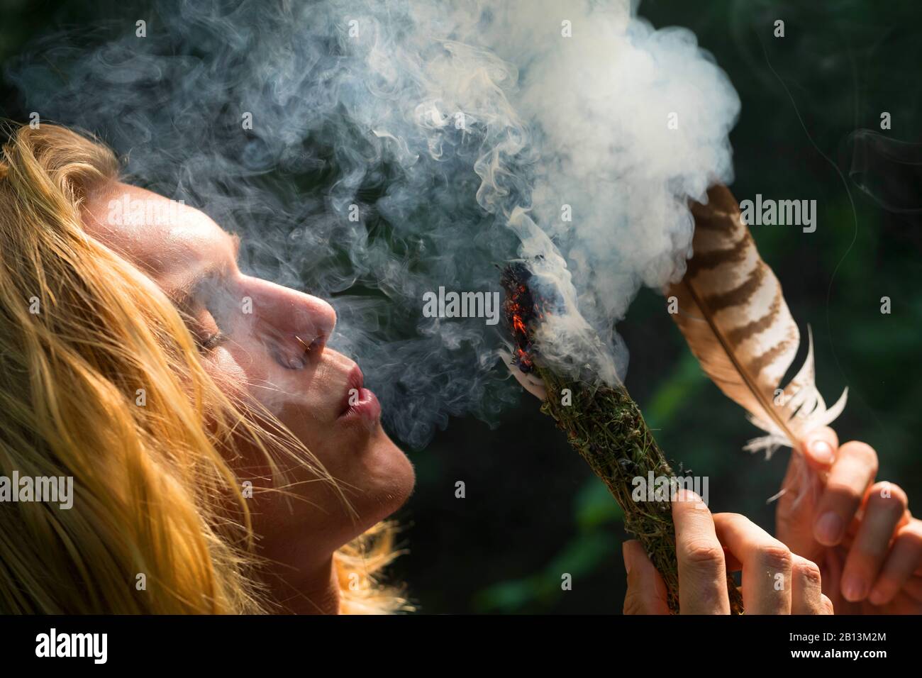 Aushärtung, junger Mann, der die Flamme bläst, Deutschland Stockfoto