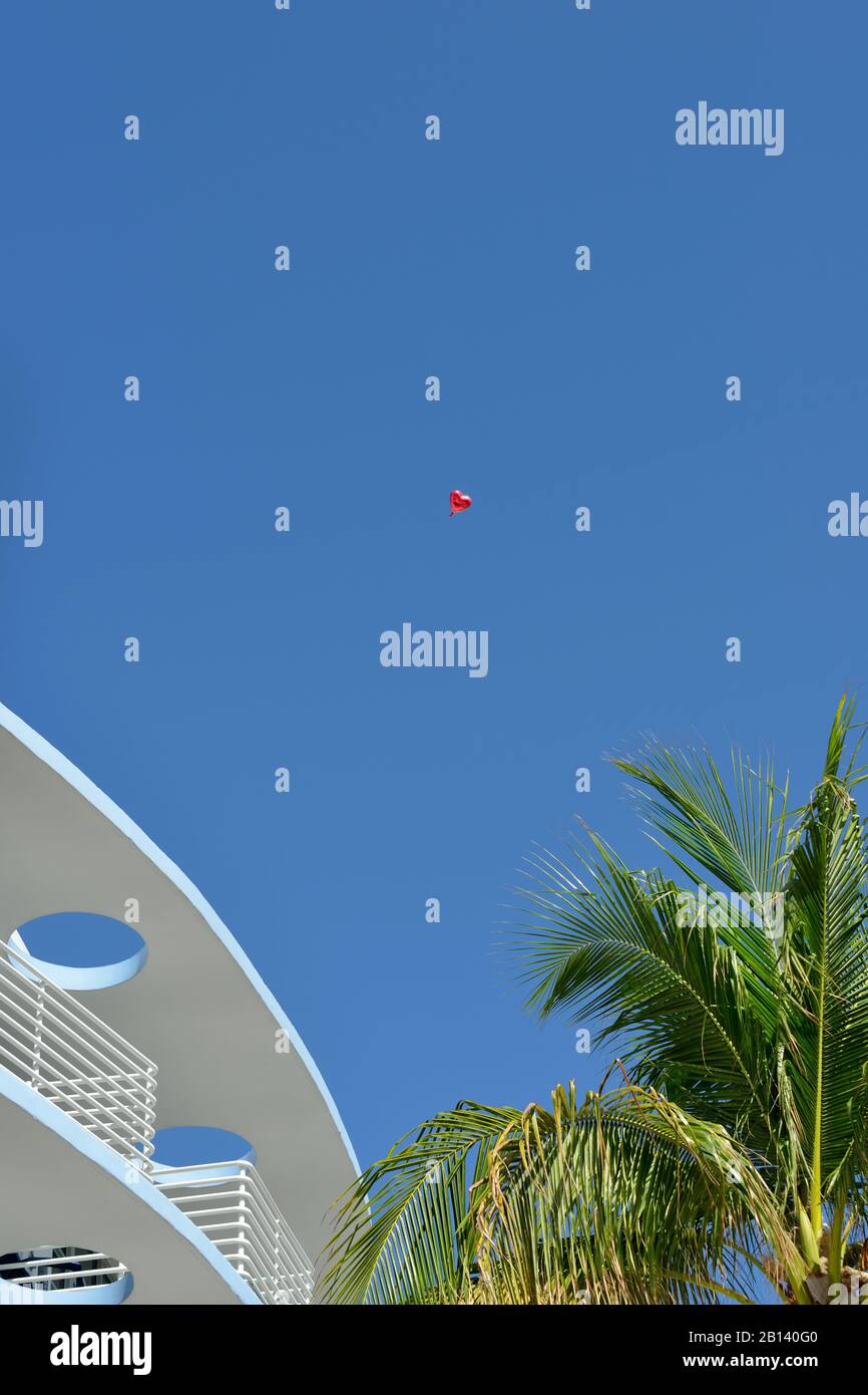 Miami Liebesgeschichte, abstrakter Hintergrund. Valentine, die über South Beach Gebäuden und Palmen wegfliegt. Stockfoto