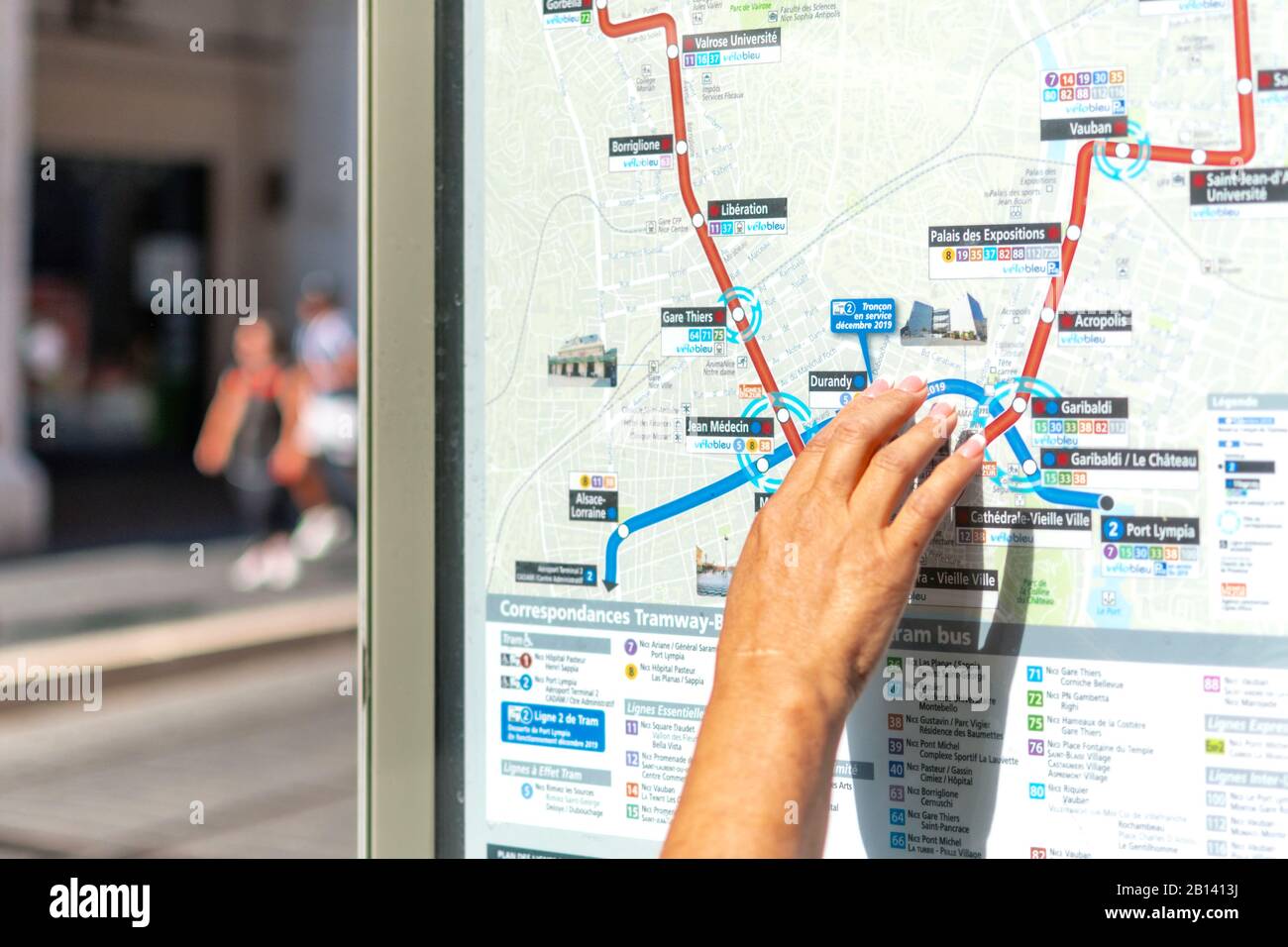 Eine weibliche Hand zeigt auf eine Straßenkarte mit Tramwegen im Stadtzentrum von Nizza, Frankreich. Stockfoto