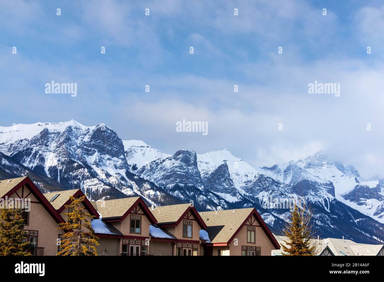 Reihen von Häusern in den kanadischen Rockies von Canmore, Alberta, mit spektakulärem Blick auf den Rundle Mountain im Hintergrund. Stockfoto