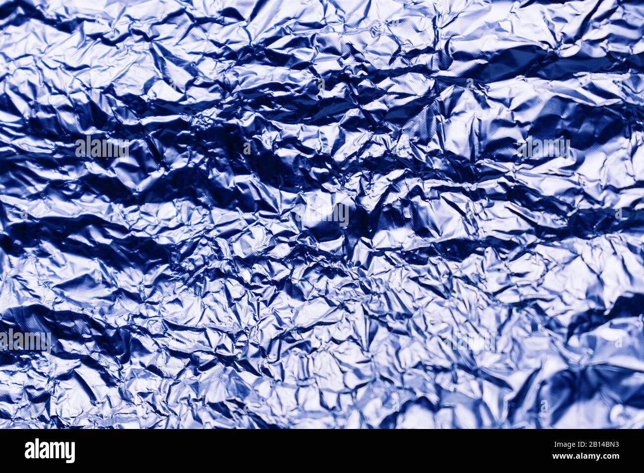 Blaue Textur aus zerknittertem Blech aus Aluminiumfolie. Folienhintergrund. Stockfoto