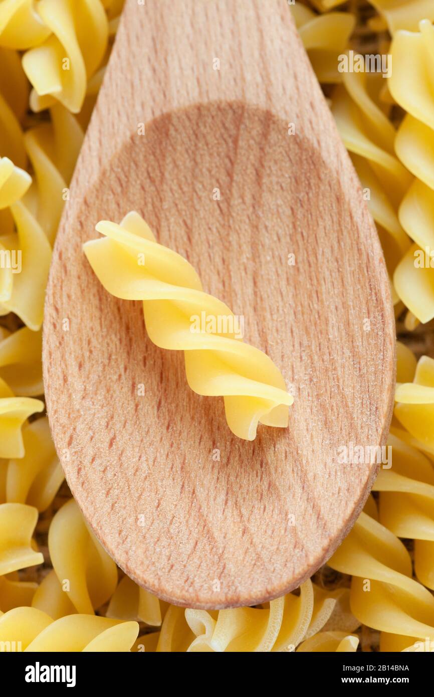 Fusilli Pasta im Holzlöffelhintergrund mit Vollrahmen. Stockfoto