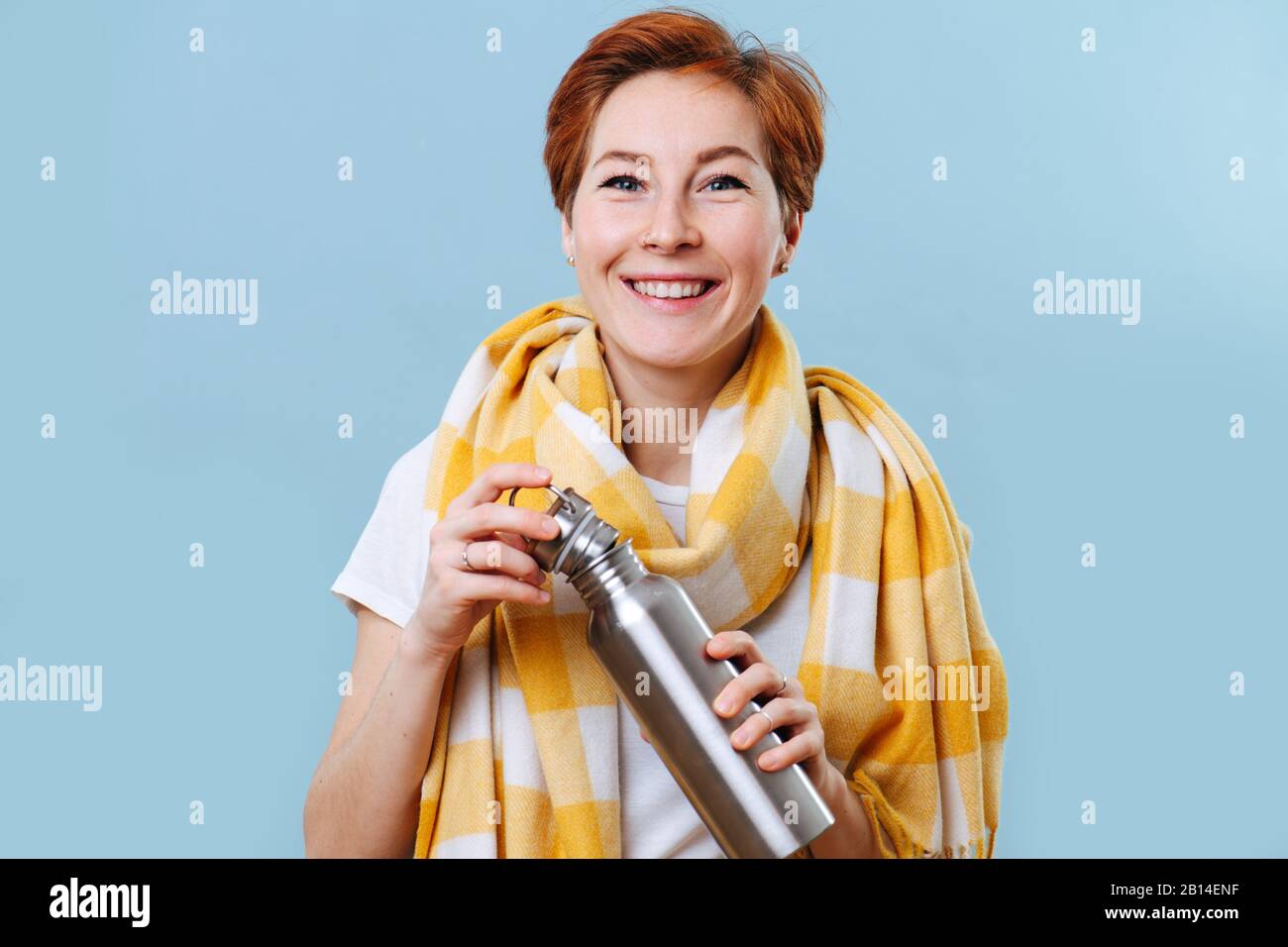 Fröhliche Sozialfrau mit Schal am Hals, die Thermoelemente mit heißem  Getränk hält Stockfotografie - Alamy