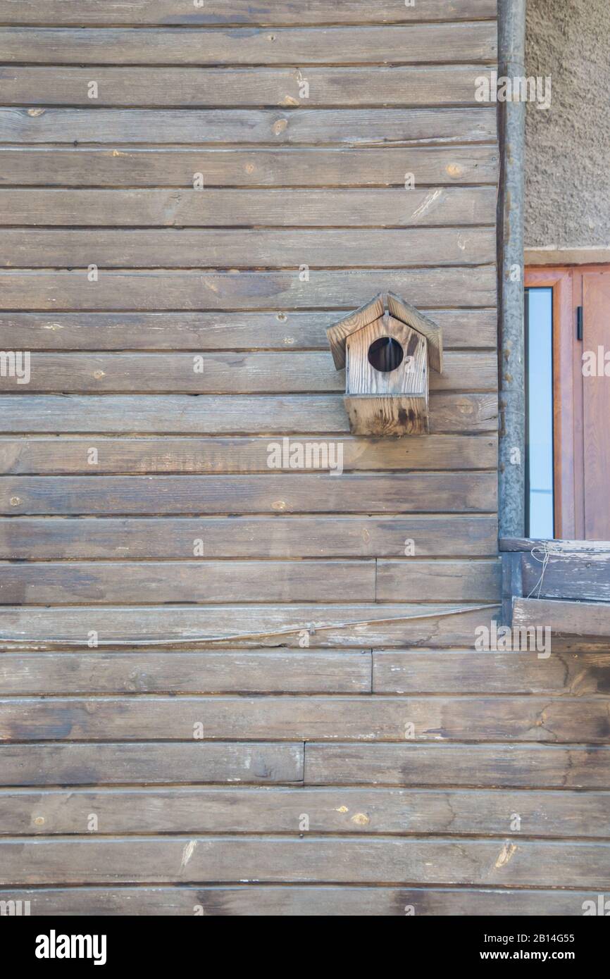 Holzbirdhouse an einer Holzwand aus Bohlen, Hintergrund, Kopierraum Stockfoto