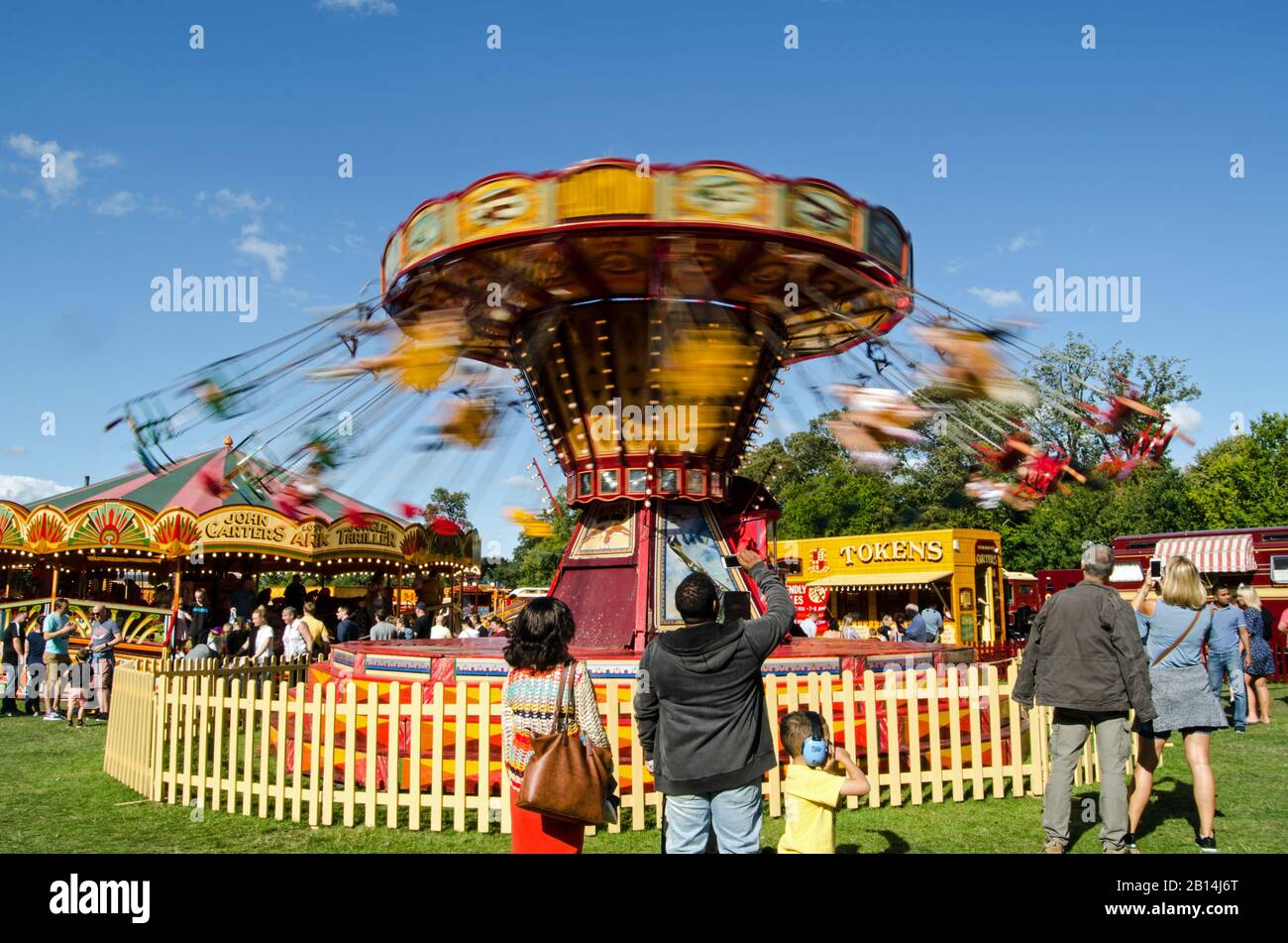 Basingstoke, Großbritannien - 1. September 2019: Zuschauer, die Menschen beobachten, die an einem sonnigen Sommertag die Fahrt mit dem Vintage Chair O Plane auf der Carter's Steam Fair genießen Stockfoto