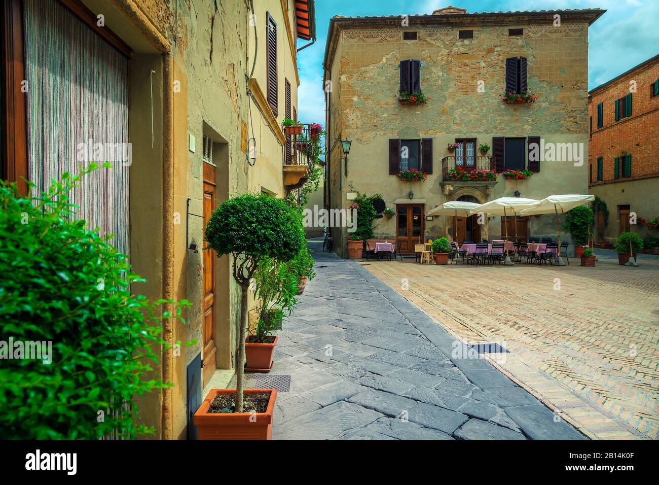 Süßes Straßencafé mit Tischen und Stühlen in der alten gepflasterten Straße Pienza, Toskana, Italien, Europa Stockfoto