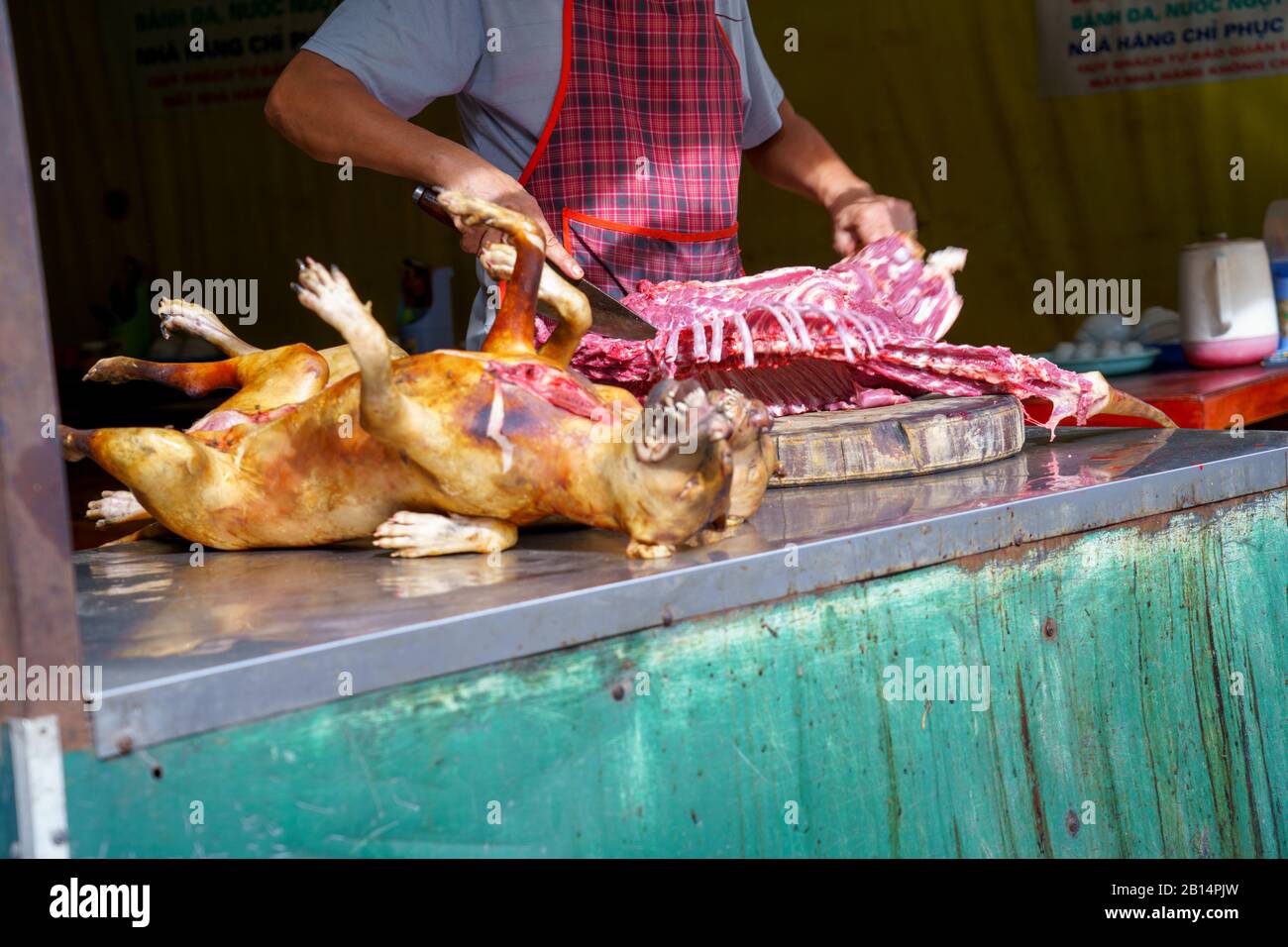 Mann seziert, Pay Hund Fleisch toter Körper verkaufen Gegrilltes für Grill Street Food von Vietnam. Essen ist schwierig. Stockfoto