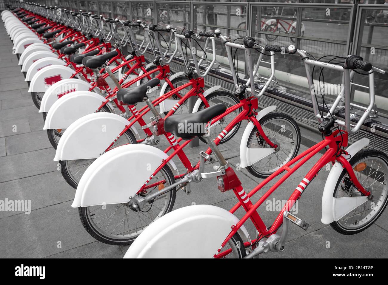 Viele Fahrrad in Folge. Rote Fahrräder stehen auf einem Mietparkplatz. Umweltfreundliches Transportkonzept. Stockfoto