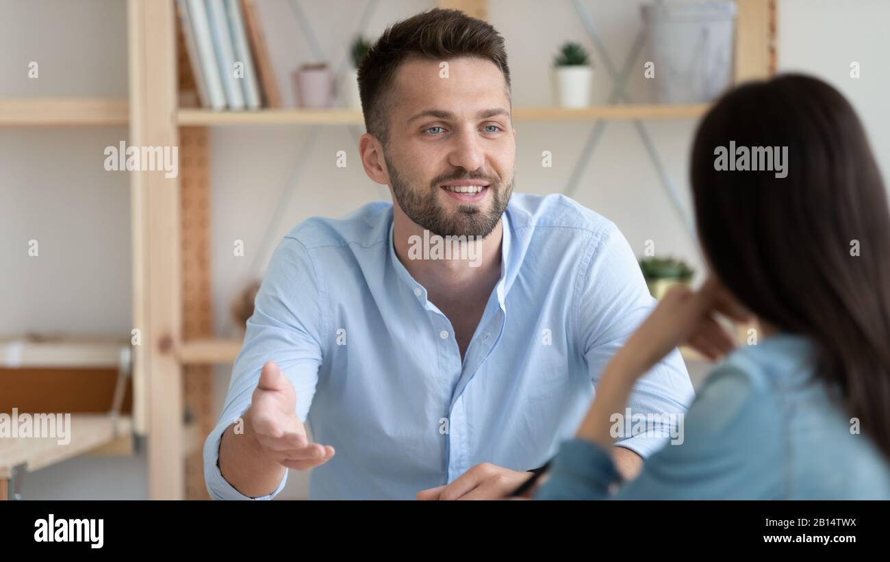 Junger Mann im Gespräch mit Kollegen im Büro Stockfoto