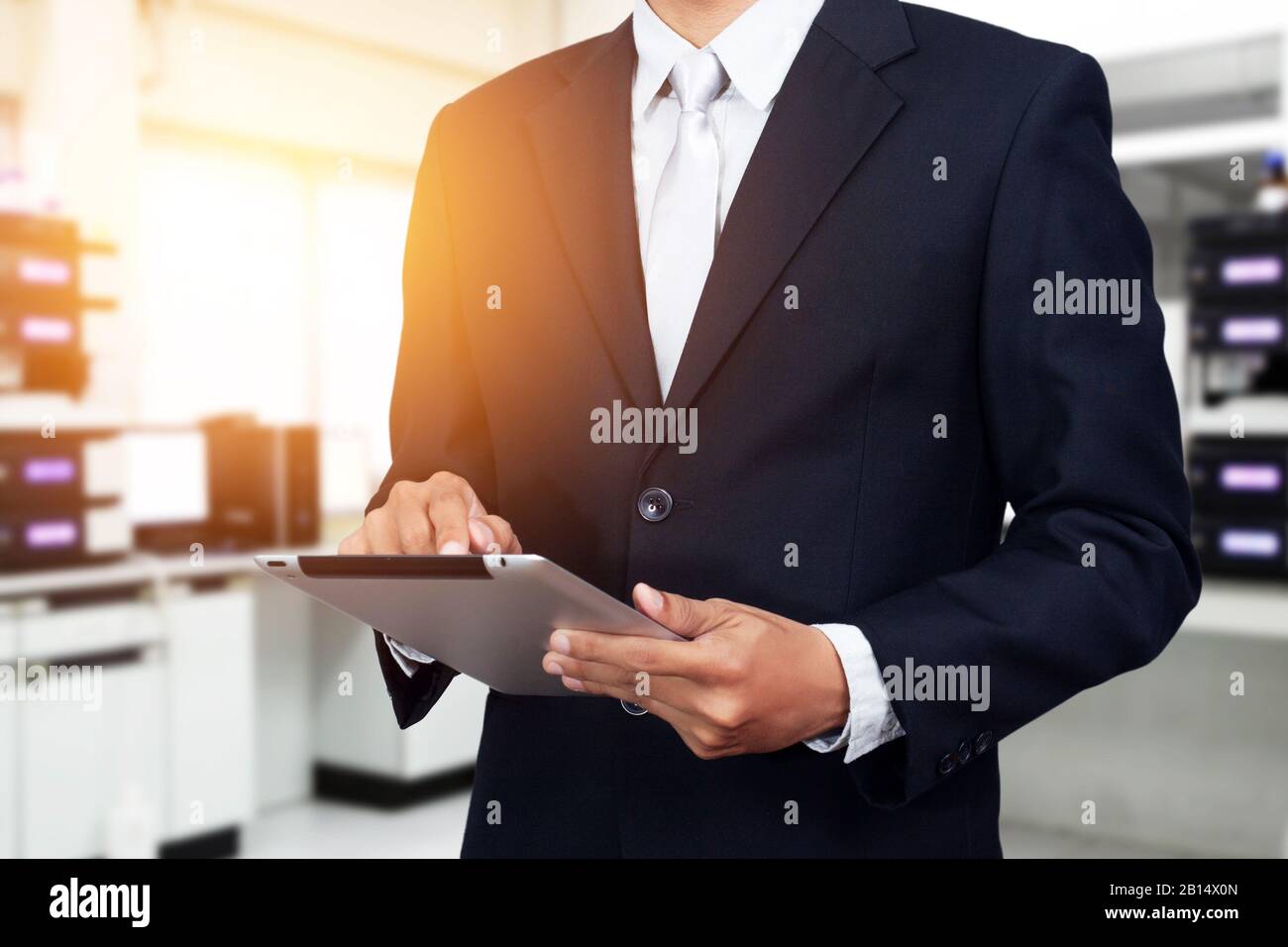 Geschäftsleute mit Tablet, digitales Technologiekonzept. Junger asiatischer Geschäftsmann, der auf einem digitalen Tablet arbeitet, während er im Büro steht. Stockfoto