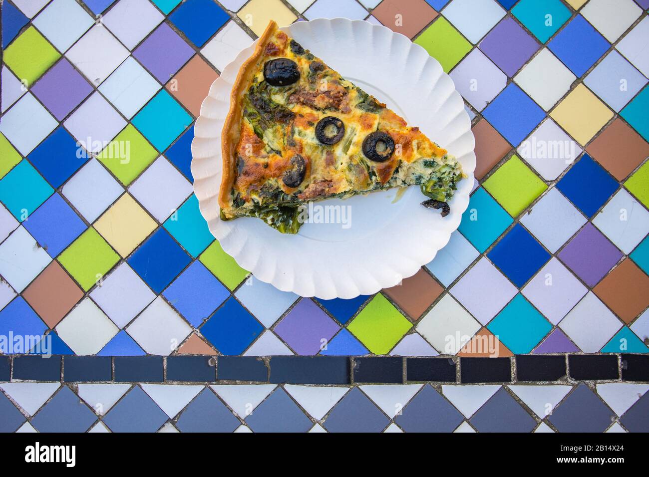 Ein Pice vegetarischer Pastete auf dem Tisch. Köstliches gesundes Essen auf farbenfrohem Hintergrund. Stockfoto