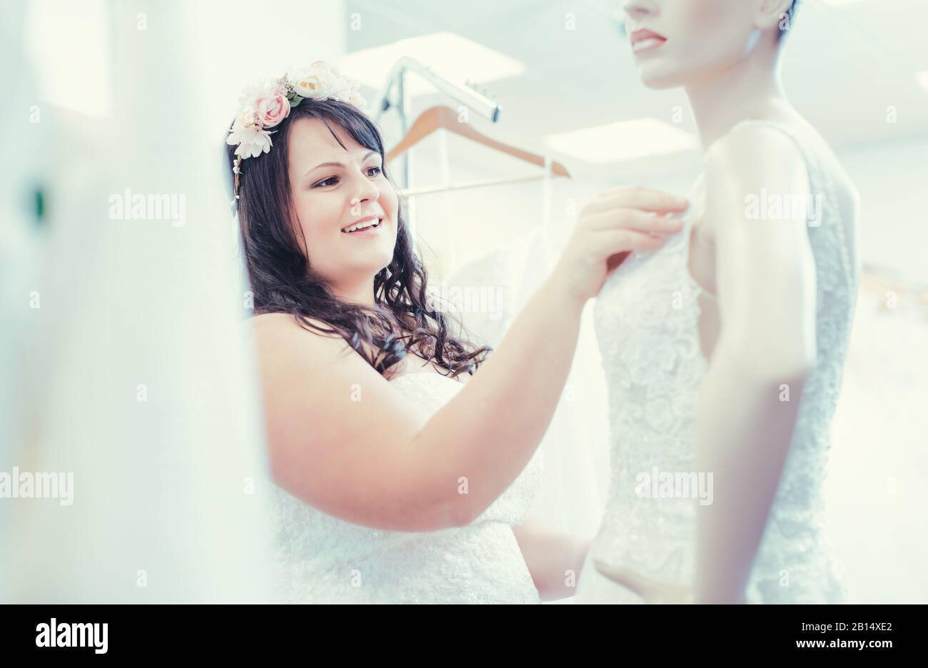 Die Frau als Braut auf der Suche nach Brautmode in einer Hochzeit Shop. Stockfoto