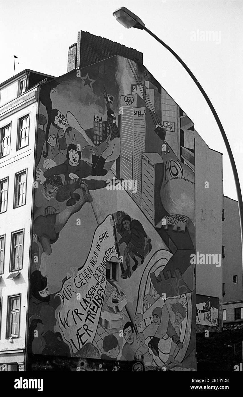 Hausbesetzer an der St. Pauli Hafenstraße, Hamburg, Deutschland, ca. 1988. Die Grafitti lautet: "Wir werden nicht in Ihre Betonghettos gehen. Wir werden uns nicht ausverkaufen." Während der 1980er Jahre waren diese Hausbesetzer ein Brennpunkt für verschiedene soziale Konflikte, mit Krawallen und gewalttätigen Auseinandersetzungen zwischen den Hausbesetzern und den Polizeikräften oder Gruppen von Faschisten, die mit Rowdys vermischt waren. Die Häuser wurden 1995 an eine Genossenschaft verkauft, um das Konfliktpotenzial zwischen den Bewohnern und dem Staat zu entschärfen. Schwarzweiß-Filmfoto Stockfoto