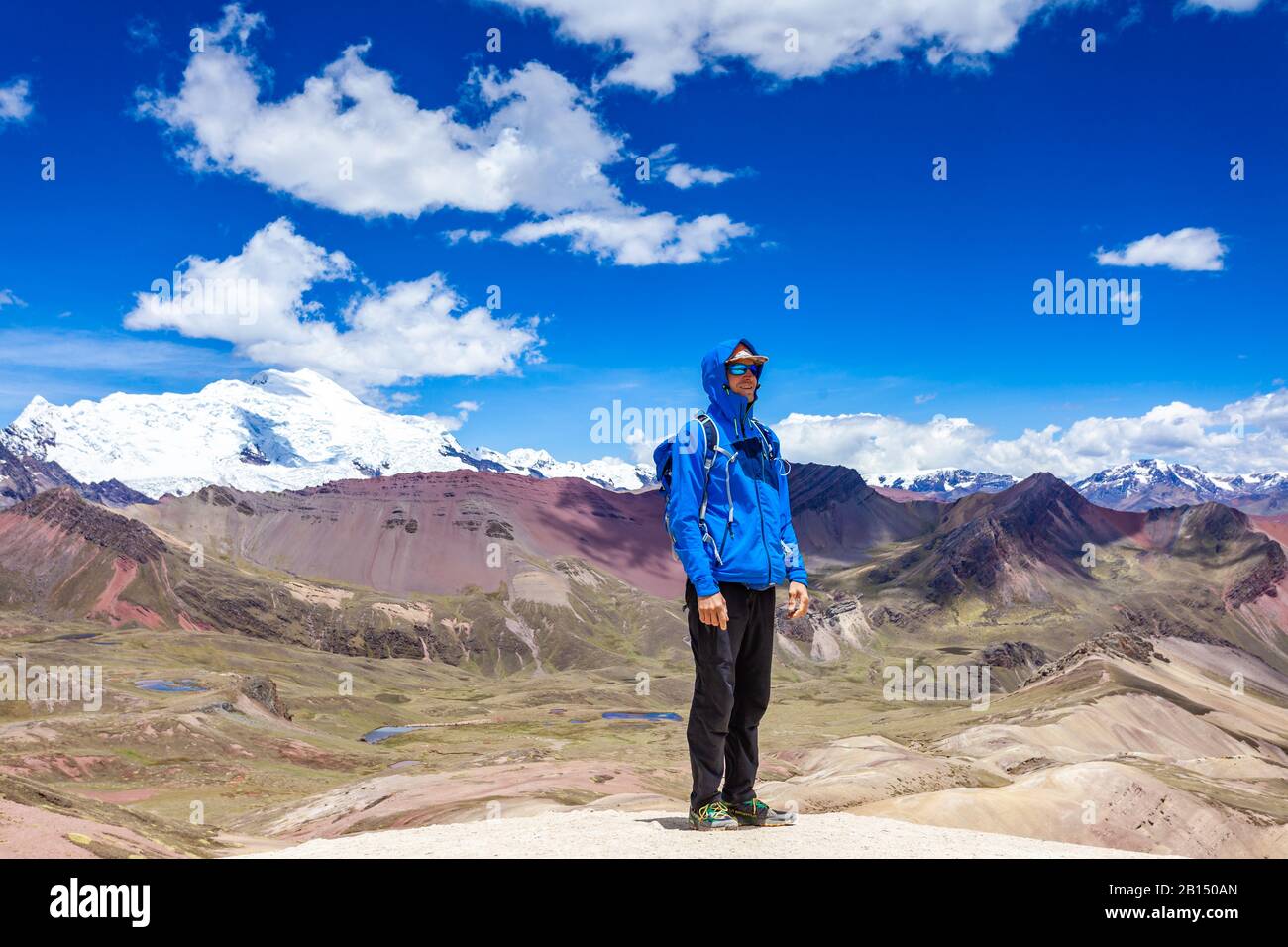 Ein glücklicher Mann steht auf dem Gipfel des Regenbogengebirges Von Peru. Peruanische Anden. Ausangate Berg. Stockfoto