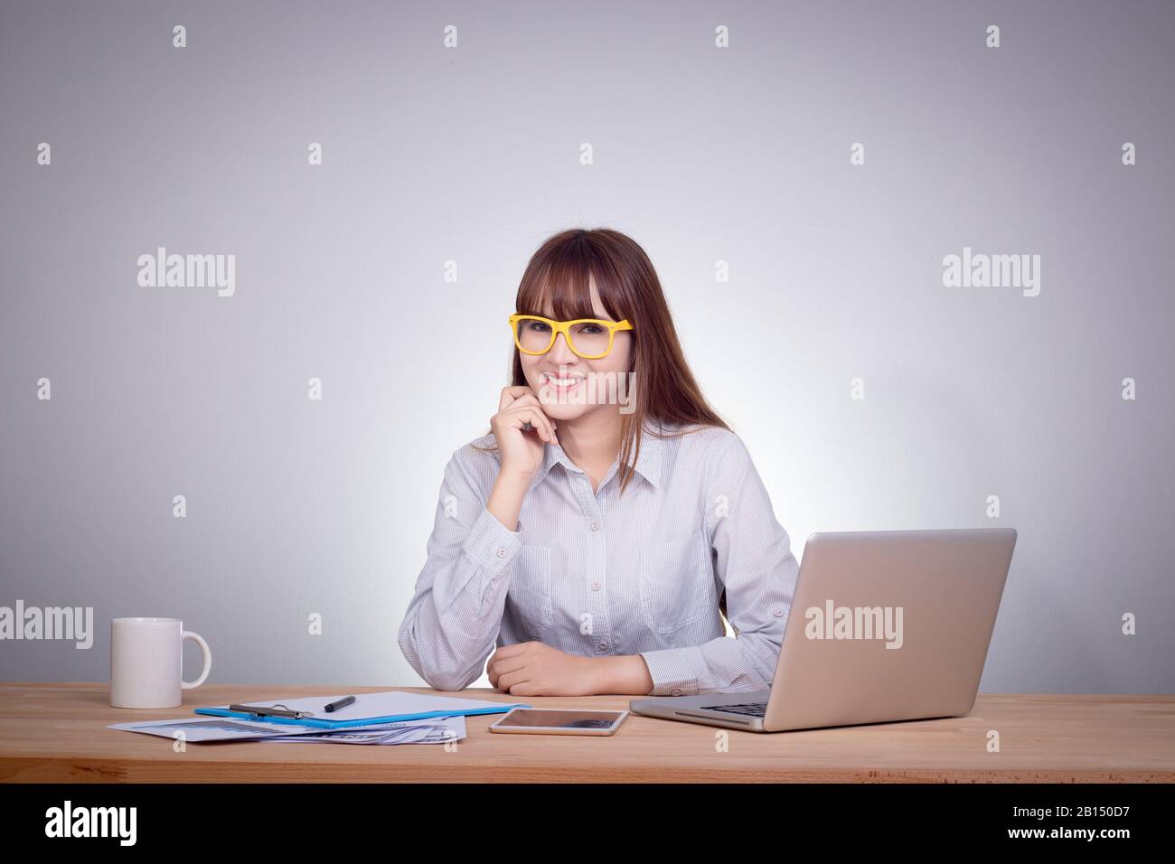 Glückliches Business Woman Konzept. Fröhliches lächelndes asiatisches Mädchen, das mit Laptop arbeitet und Kaffee trinkt, während sie an einem neuen Projekt in ihrem Heimbüro arbeitet. Jung Stockfoto