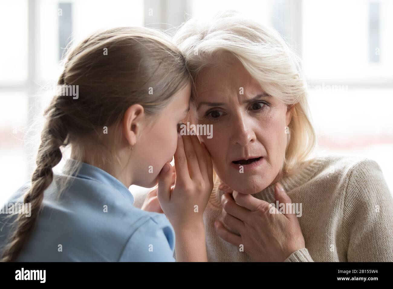 Trauriges kleines Mädchen, das sich über Probleme bei der Großmutter beschwert. Stockfoto