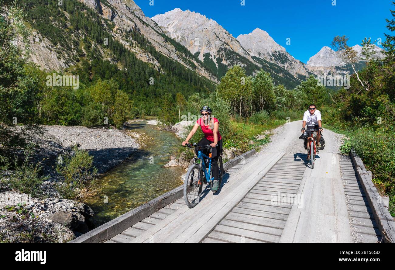 Radfahrer, Mountainbiker radeln auf Brücke über Bergbach, Schotterweg nach Karwendelhaus, Karwendeltal, Tyrol, Österreich Stockfoto