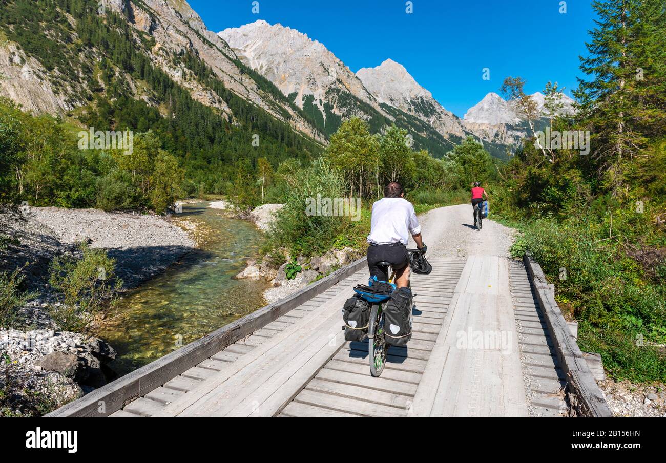Radfahrer, Mountainbiker radeln auf Brücke über Bergbach, Schotterweg nach Karwendelhaus, Karwendeltal, Tyrol, Österreich Stockfoto