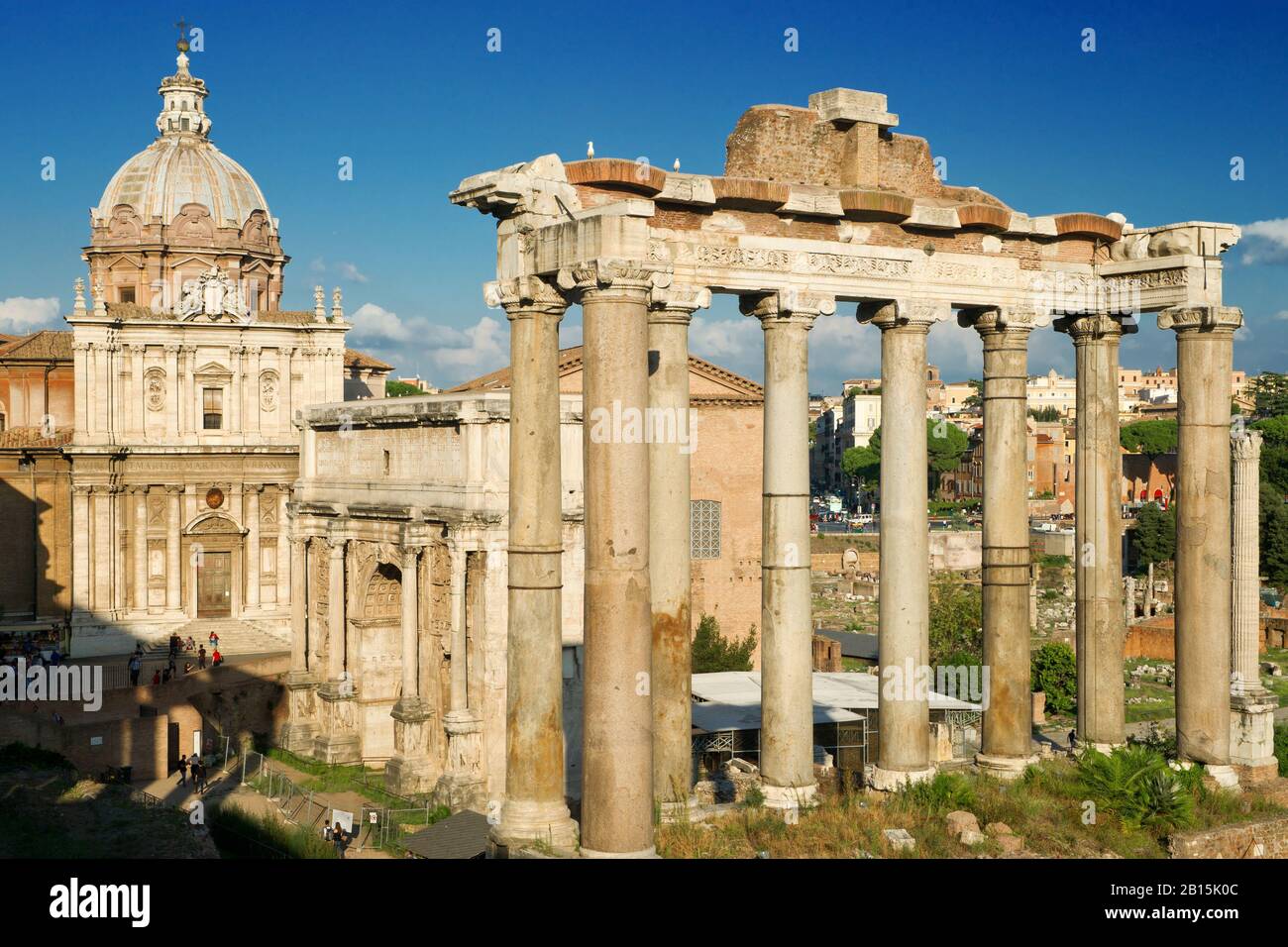 Die Säulen des Saturntempels, des Septimius-Severus-Bogens und der mittelalterlichen Kirche im Forum Romanum, Rom, Italien Stockfoto