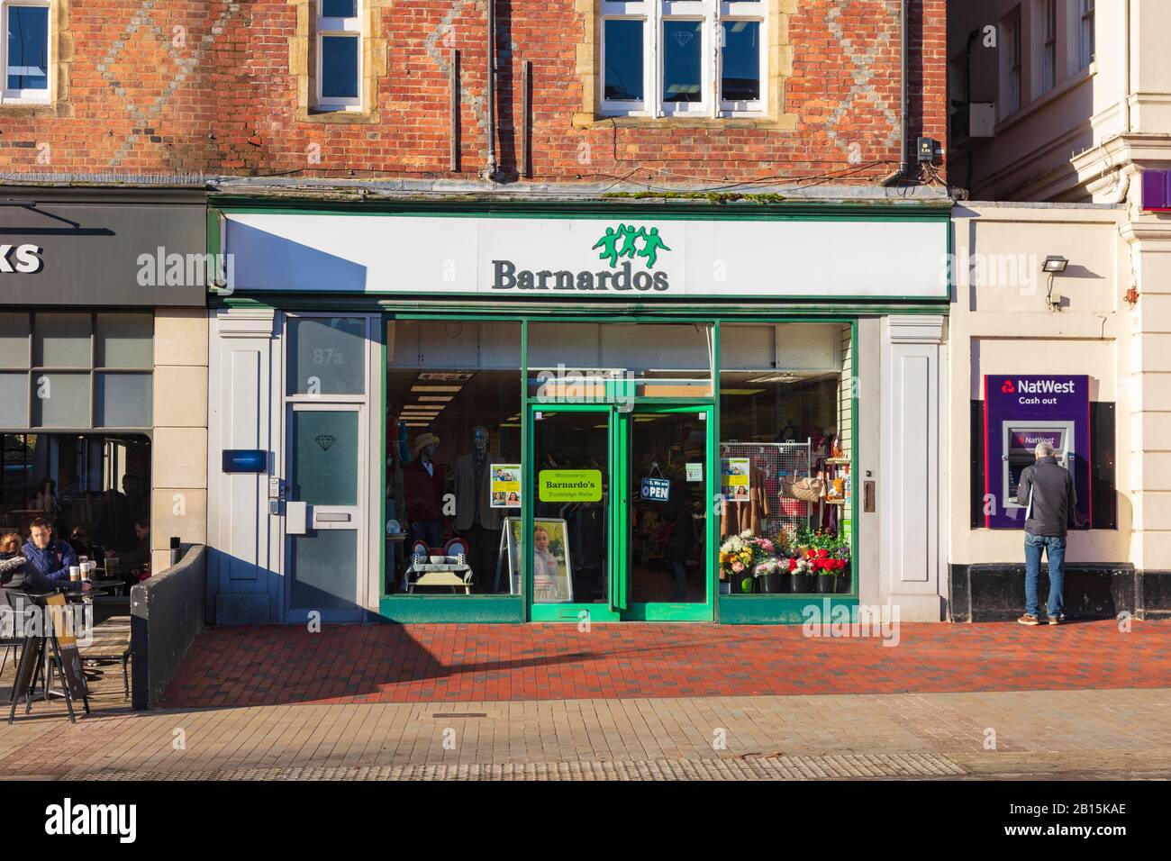 Barnardos Charity Shop an der Mount Pleasant Road, Tunbridge Wells, mit einem Geldautomat Nebenan, Kent, Großbritannien Stockfoto