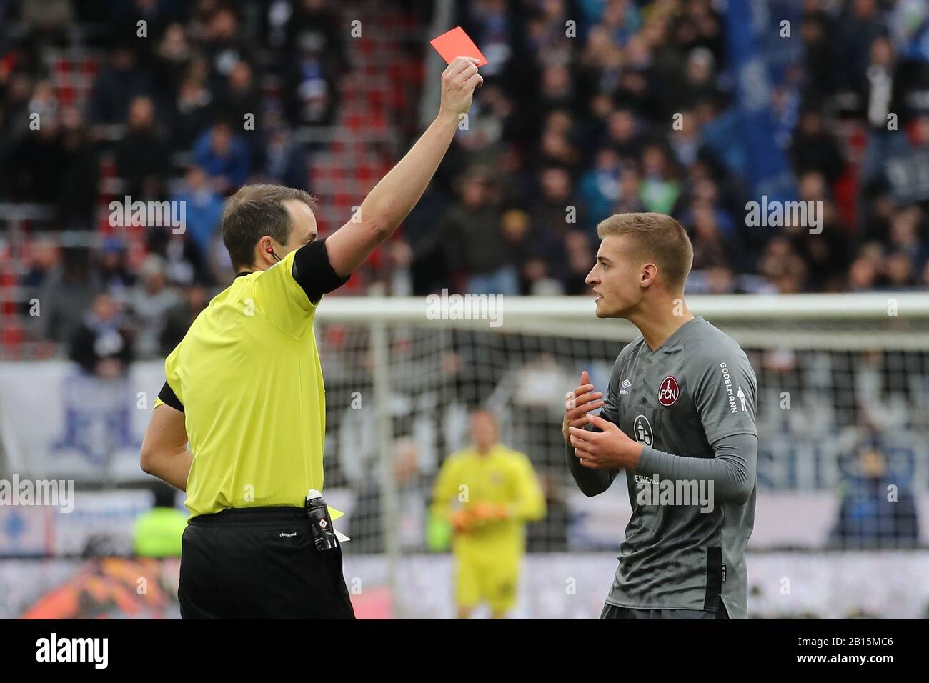 Nürnberg, Deutschland. Februar 2020. Fußball: 2. Bundesliga, 1. FC Nürnberg - Darmstädter 98, 23. Spieltag im Max Morlock-Stadion. Der Schiedsrichter Patrick Alt (l) zeigt Fabian Nürnberger die Rote Karte. Kredit: Daniel Karmann / dpa - WICHTIGER HINWEIS: Gemäß den Vorschriften der DFL Deutsche Fußball Liga und des DFB Deutscher Fußball-Bund ist es untersagt, im Stadion und/oder aus dem fotografierten Spiel in Form von Sequenzbildern und/oder videoähnlichen Fotoserien auszunutzen oder auszunutzen./dpa/Alamy Live News Stockfoto