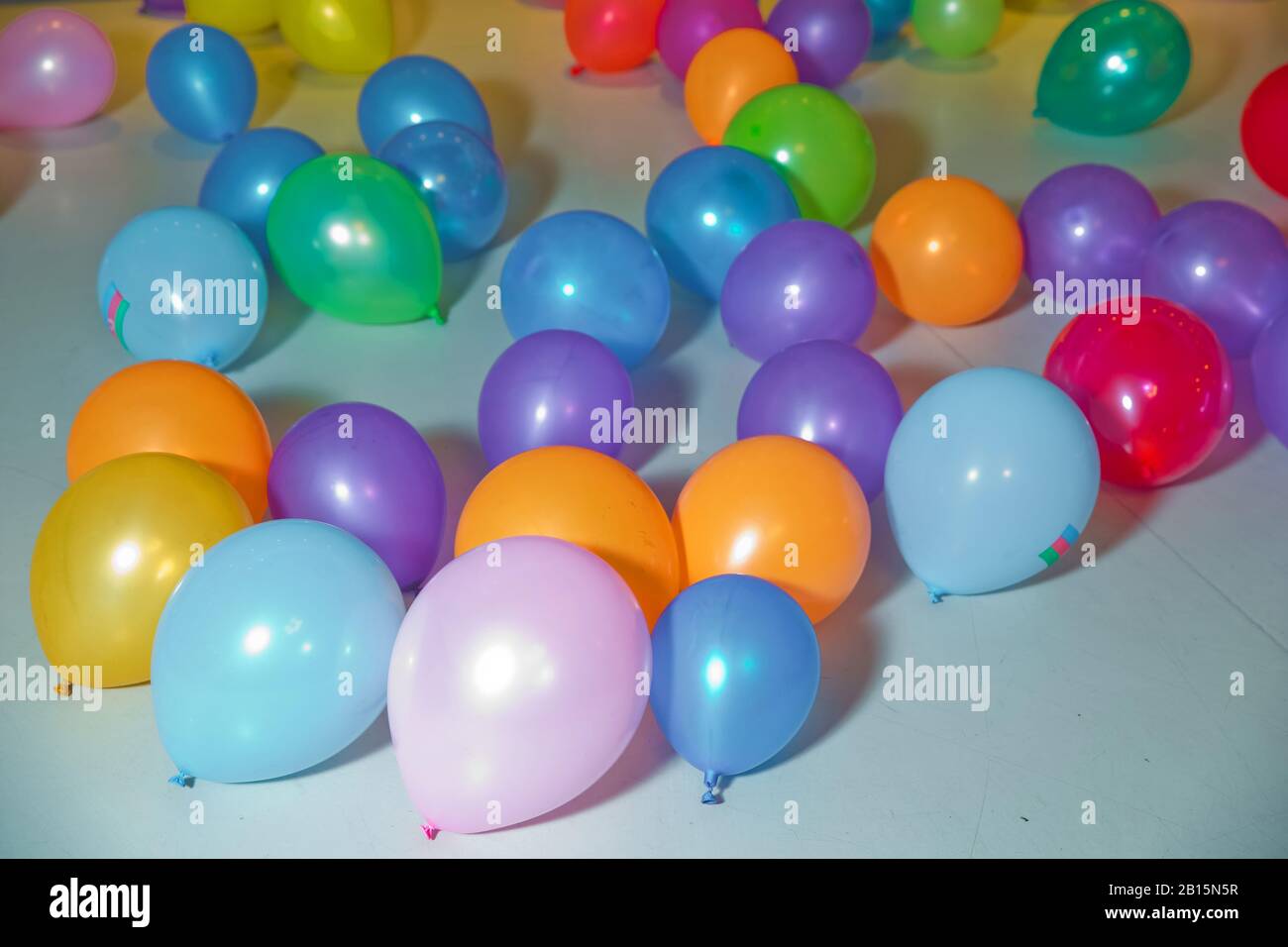 Flat Lay of bunt Ballons . Urlaub, Kinderparty, ein Spielzimmer, eine Kiste mit kleinen farbigen Bällen . Verschiedene Farbballons auf dem Boden Stockfoto